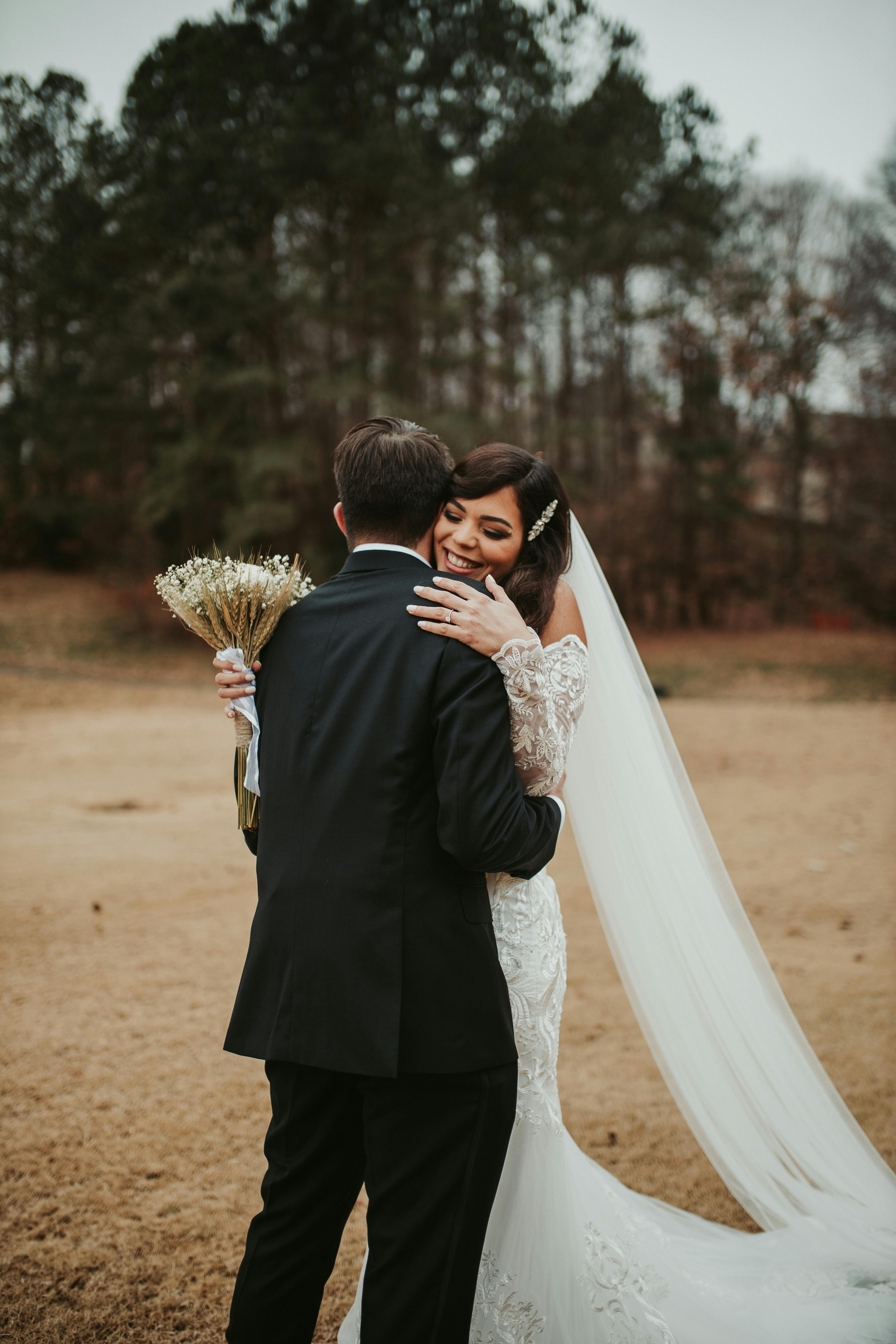 Eine Braut, die einen Mann an ihrem Hochzeitstag umarmt | Quelle: Pexels