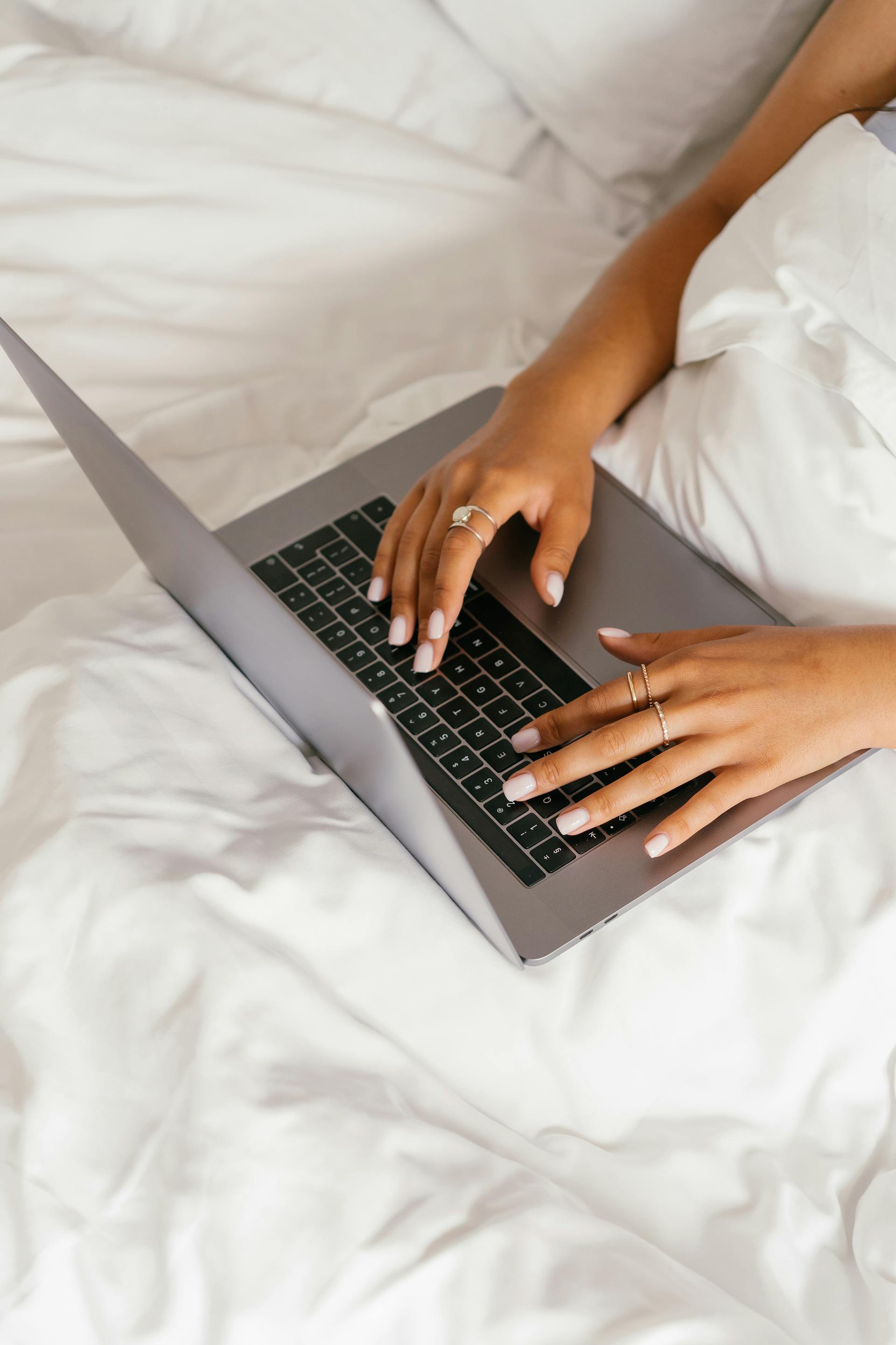 Eine Frau benutzt ihren Laptop im Bett | Quelle: Pexels