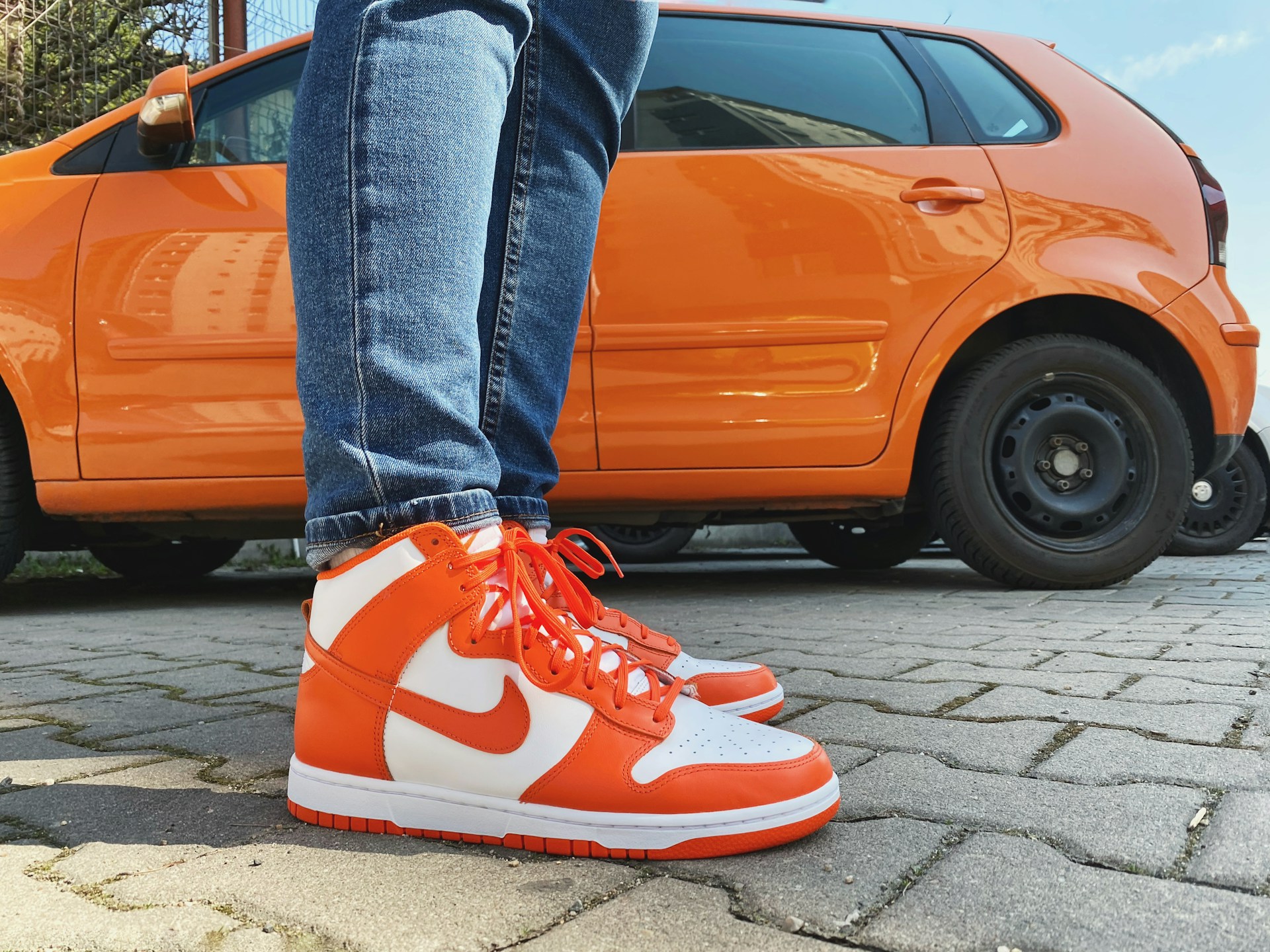 Ein Mann mit Markenschuhen, der neben einem Auto steht | Quelle: Unsplash