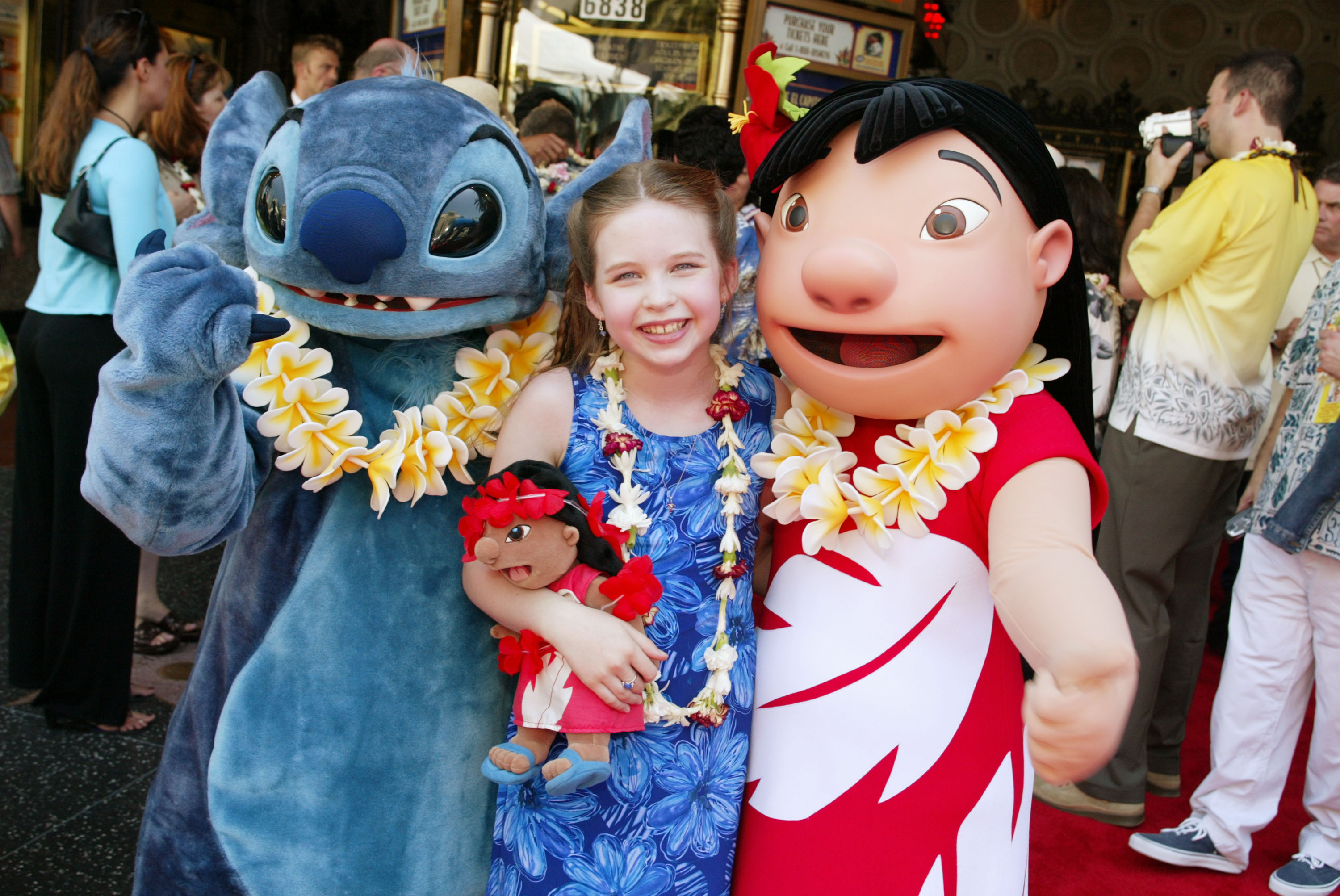 Daveigh Chase lächelt zwischen den Maskottchen Stitch und Lilo, während sie an der Premiere und der After-Party für „Lilo & Stitch“ im El Capitan Theatre in Los Angeles teilnimmt, kurz nachdem sie die animierte Heldin auf der Leinwand zum Leben erweckt hatte. | Quelle: Getty Images