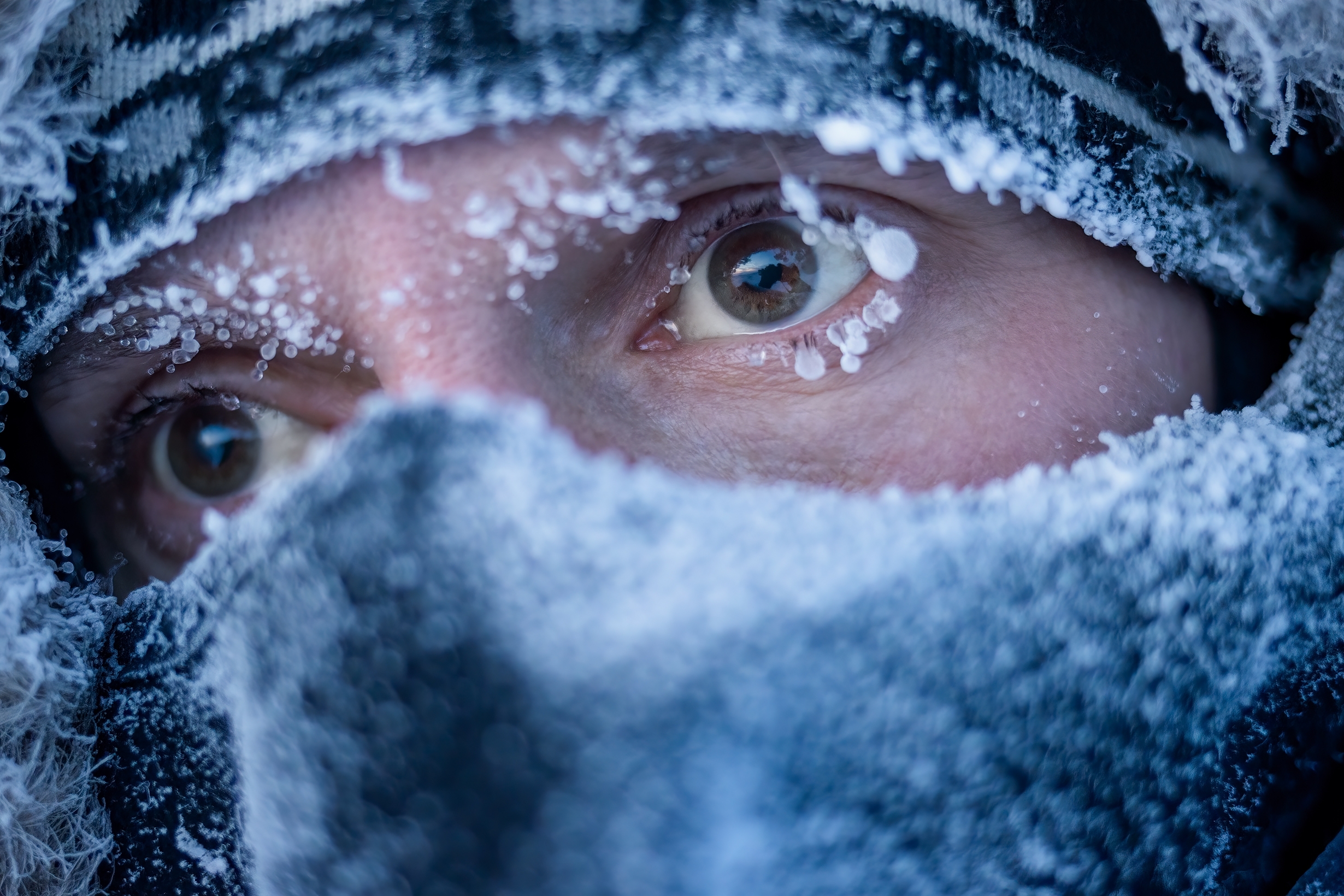 Das maskierte Gesicht eines Mannes an einem verschneiten Tag. | Quelle: Shutterstock