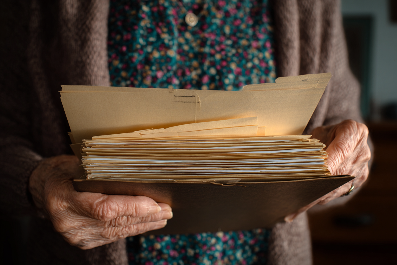 Starsza kobieta trzymająca teczkę | Źródło: Midjourney