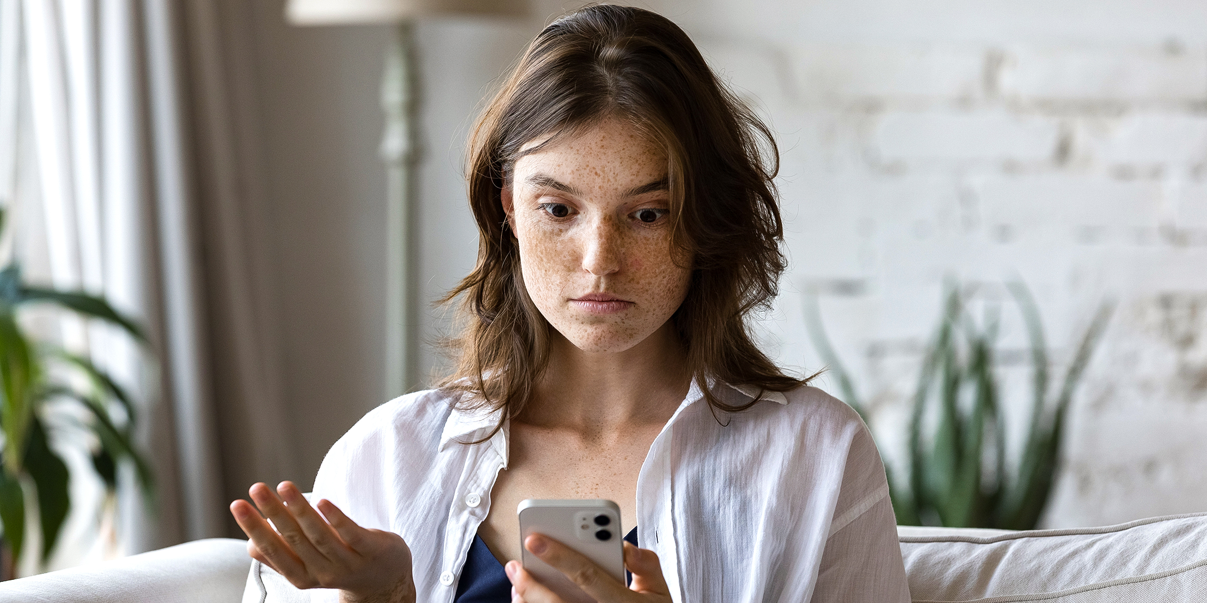 Frau starrt auf ihr Telefon | Quelle: Shutterstock