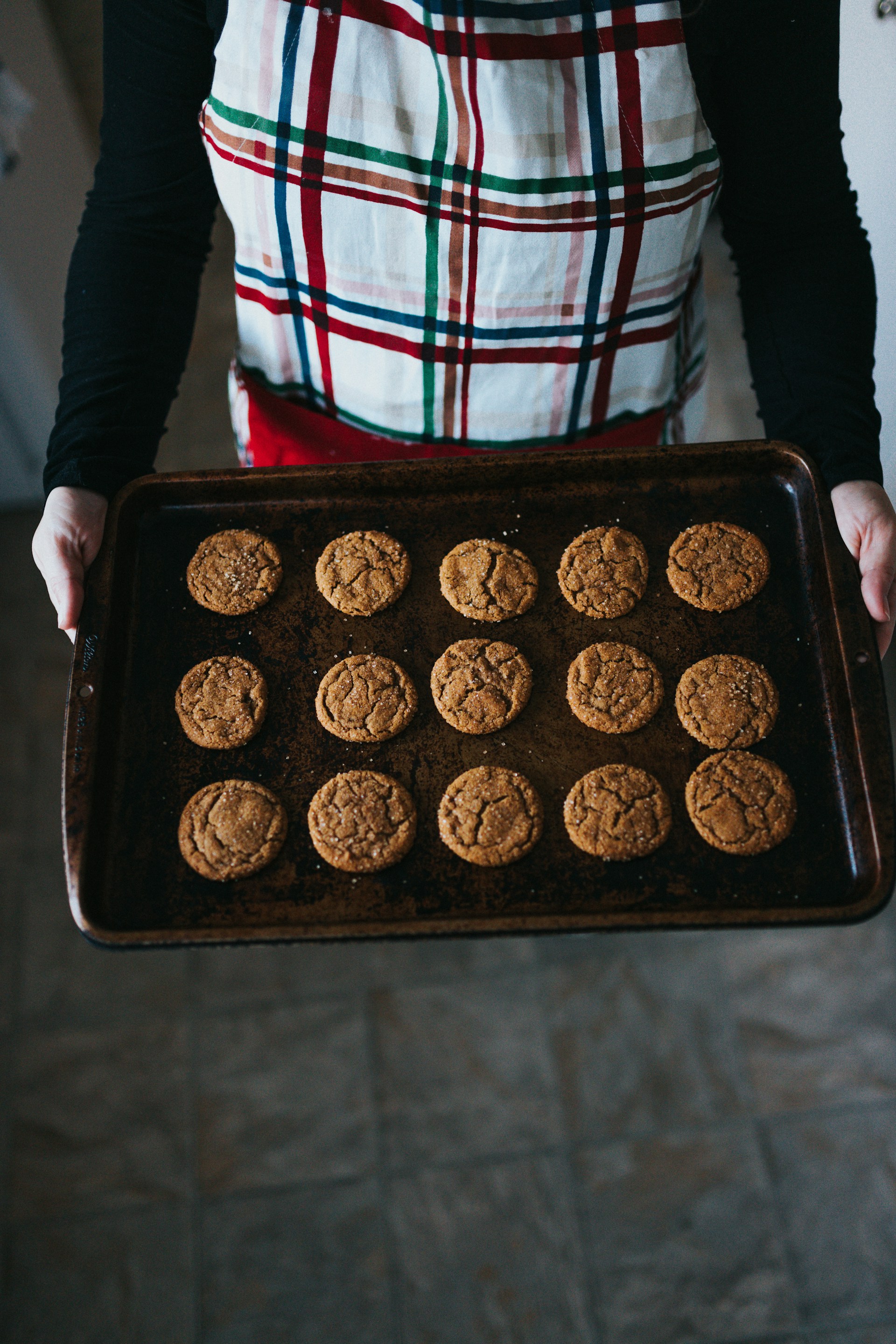 Eine Frau hält ein Backblech mit Keksen | Quelle: Unsplash