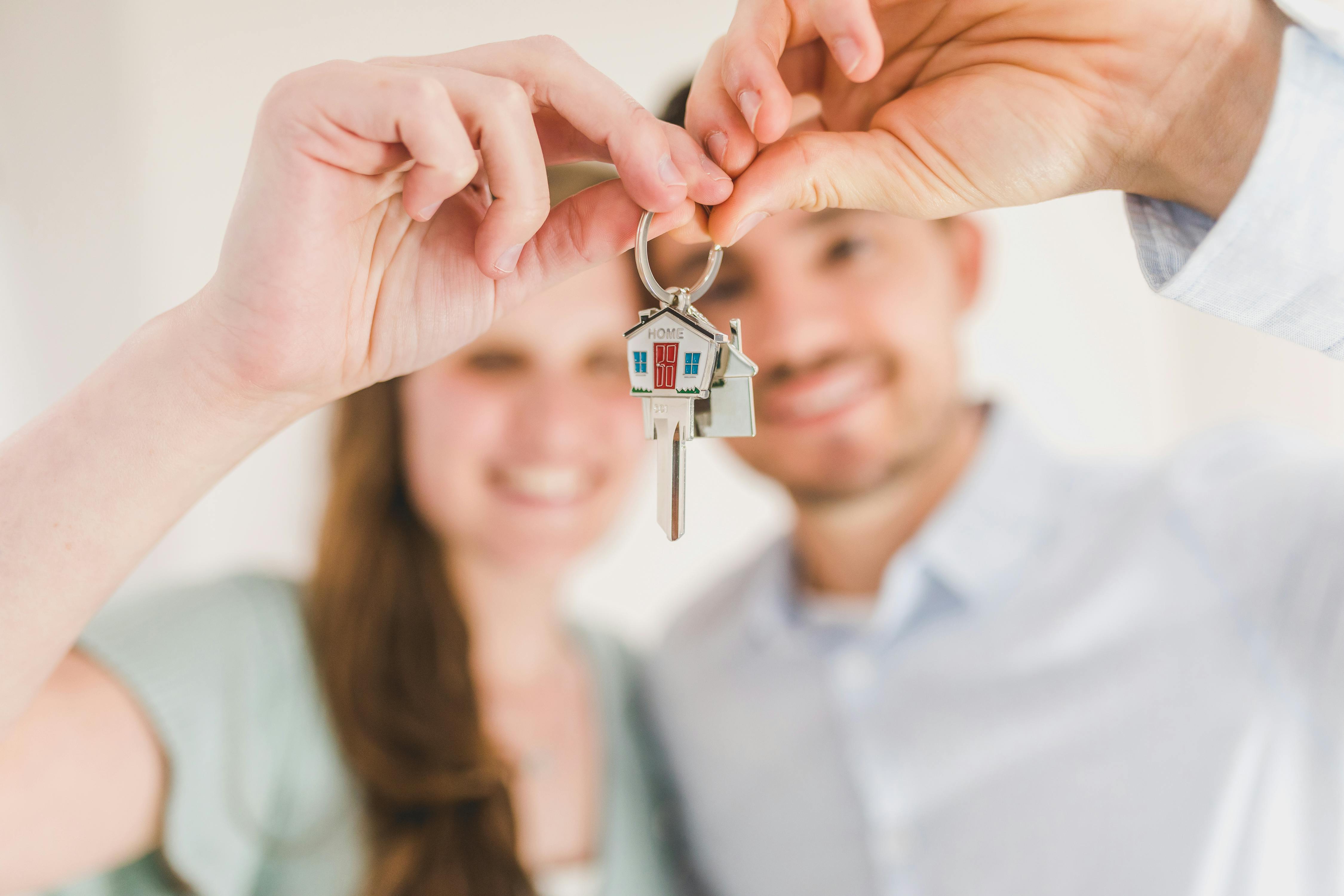 Ein junges Paar hält einen Satz Hausschlüssel hoch | Quelle: RDNE Stock project on Pexels