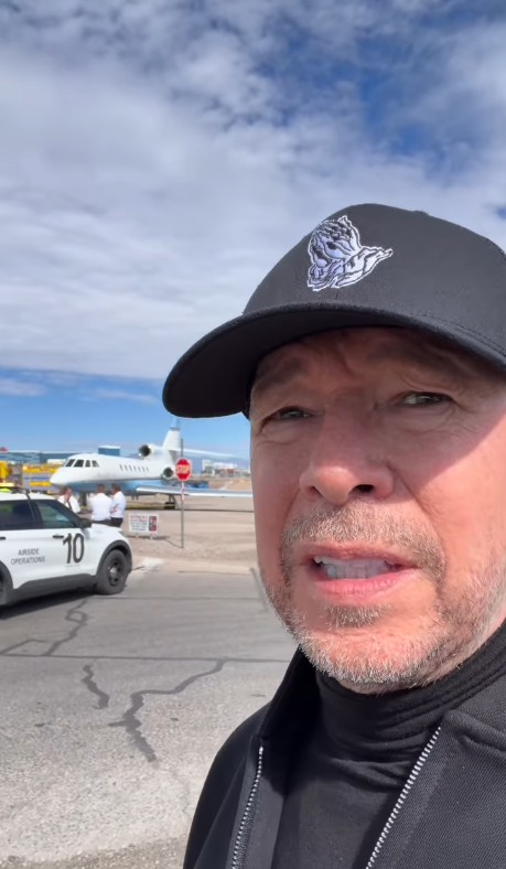 Donnie Wahlberg nimmt am 18. Oktober 2026 in der Nähe des Harry Reid International Airport in Las Vegas ein Video auf, nachdem der Start seines Privatjets abgebrochen wurde. Hinter ihm sind ein Flugzeug und ein Flughafen-Dienstfahrzeug zu sehen, während er auf die Bedenken bezüglich des Vorfalls eingeht. | Quelle: Instagram/donniewahlberg