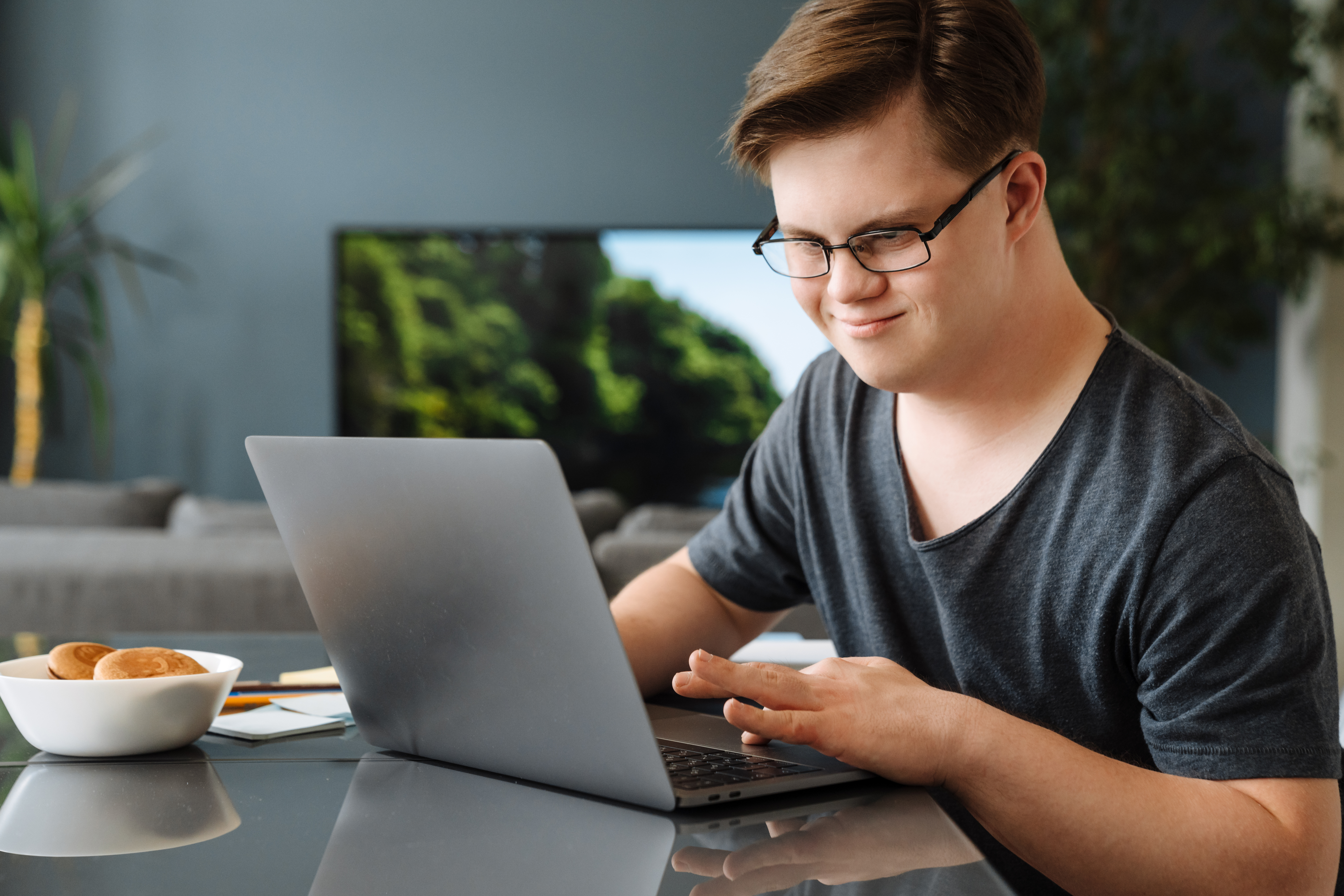 Ein Mann mit Down-Syndrom arbeitet an seinem Laptop. | Quelle: Shutterstock