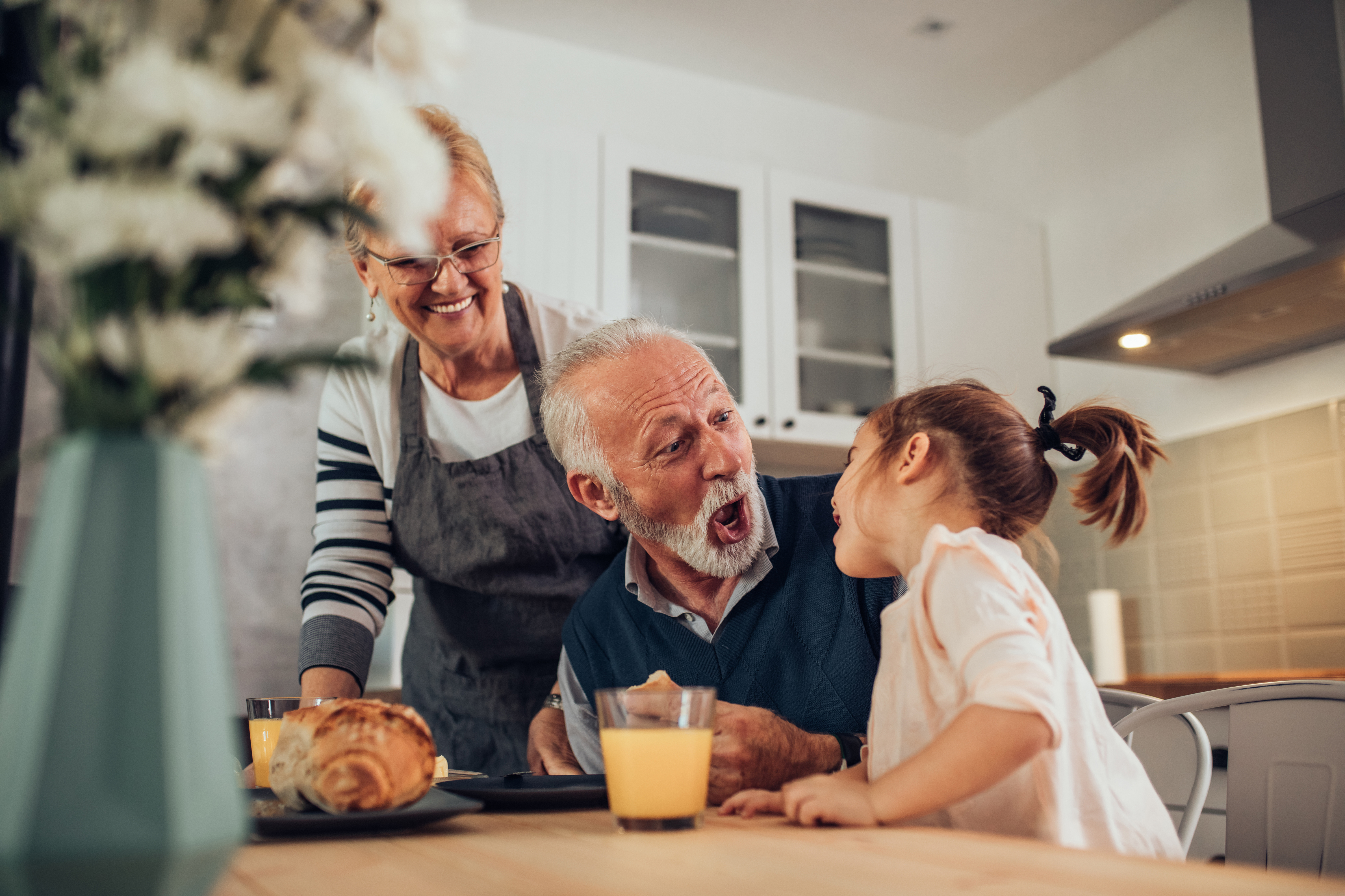 Großeltern genießen eine Mahlzeit mit ihrer Enkelin | Quelle: Shutterstock