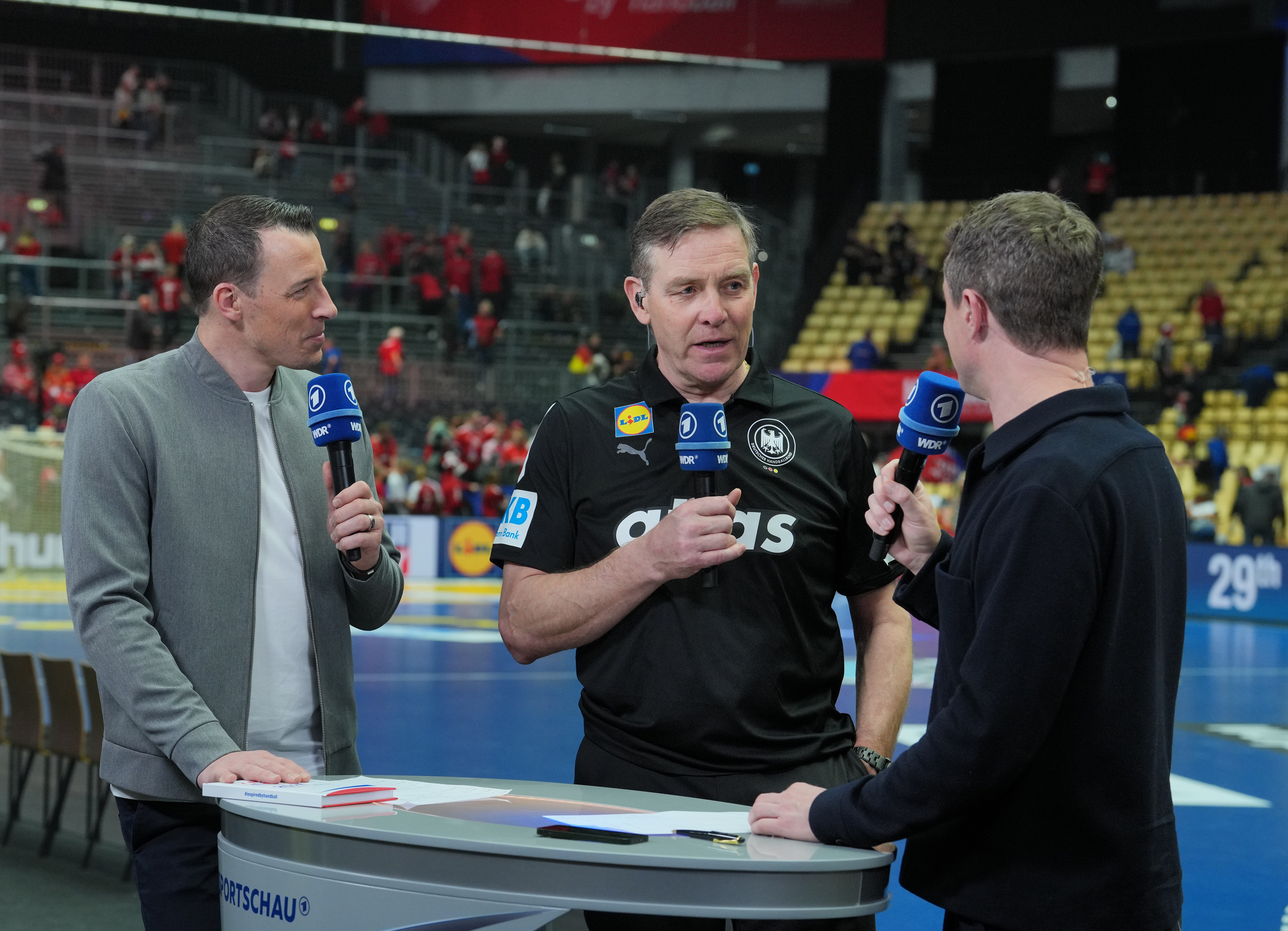 Der deutsche Nationaltrainer Alfred Gislason (Mitte) im ARD-Interview mit dem ehemaligen Nationalspieler Dominik Klein (links) und Alexander Bommes während der Handball-WM | Quelle: Getty Images