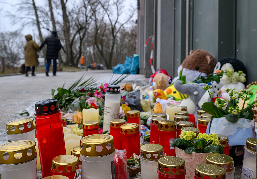 16. Februar 2026, Berlin: Plüschtiere, Blumen, Babyschuhe, Kerzen und Grablichter stehen am Eingang des Hochhauses in der Dolgenseestraße, wo bei einem Brand mehrere Leute ums Leben gekommen sind. | Quelle: Getty Images