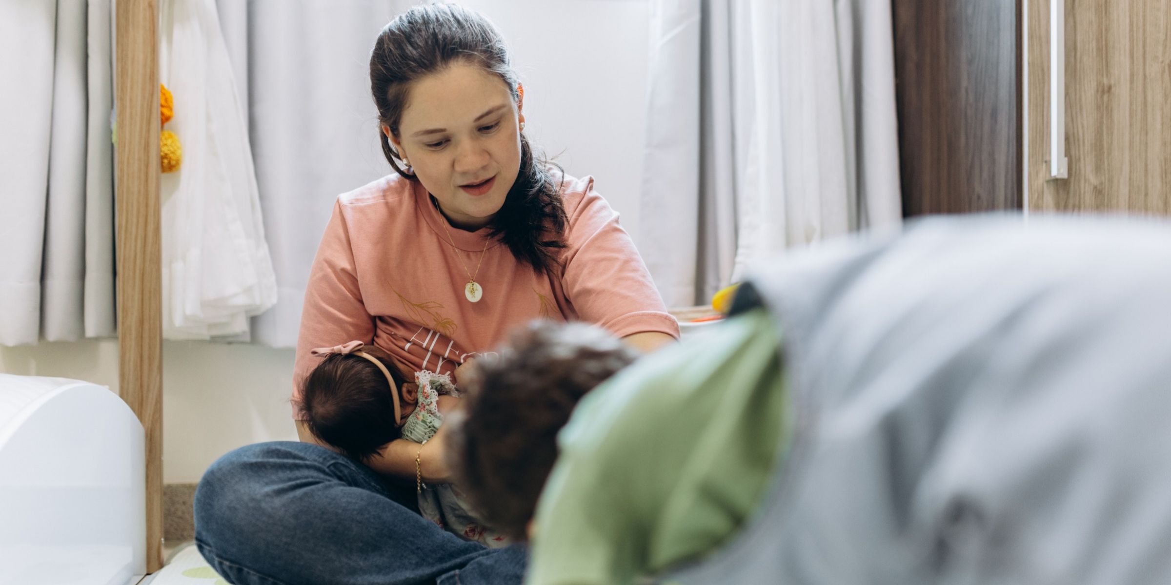 Eine Frau, die auf dem Boden sitzt und ein Baby im Arm hält | Quelle: Pexels