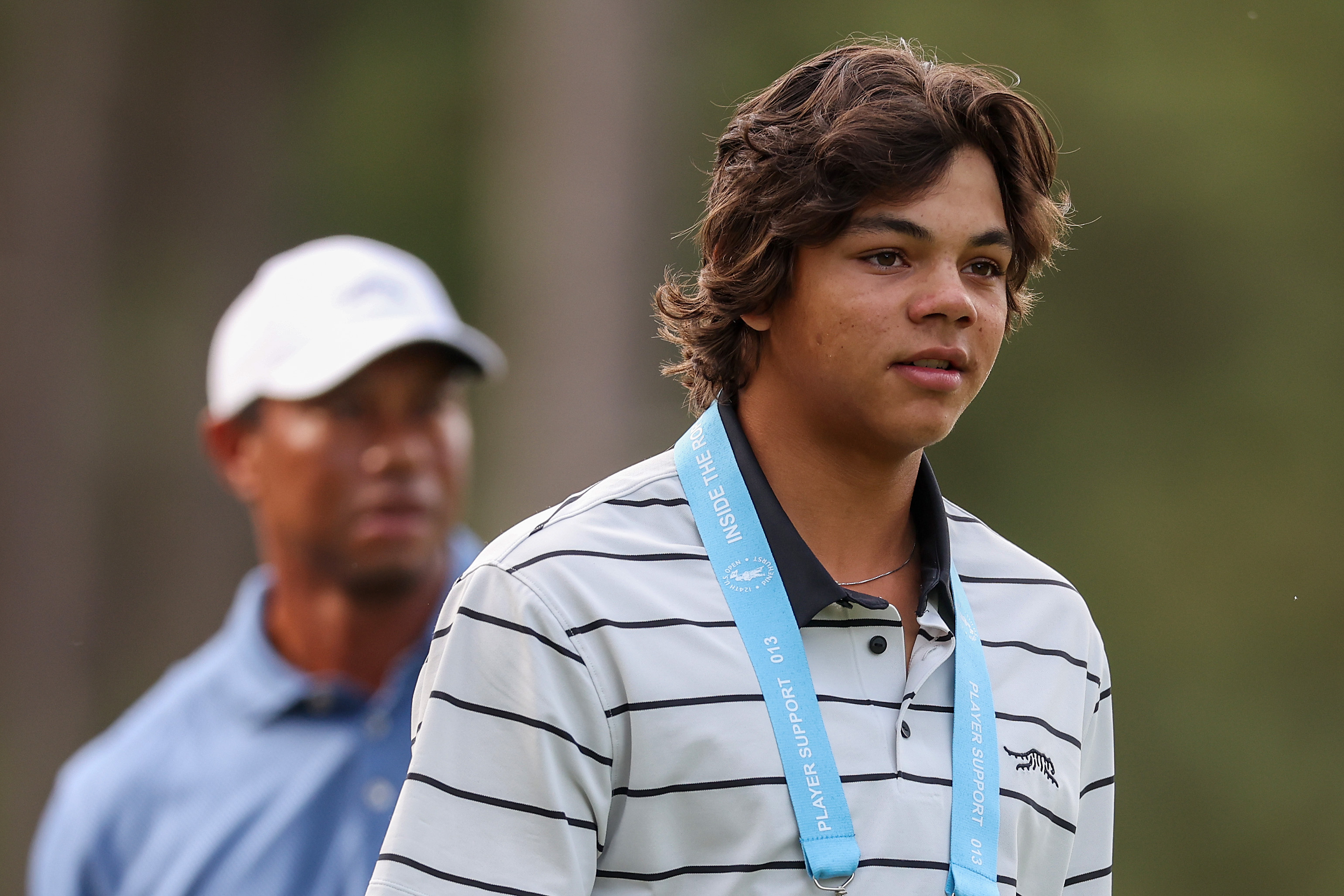 Charlie Woods schaut ernst vor seinem Vater Tiger Woods während einer Trainingsrunde vor den U.S. Open im Pinehurst Resort in North Carolina am 10. Juni 2024. | Quelle: Getty Images