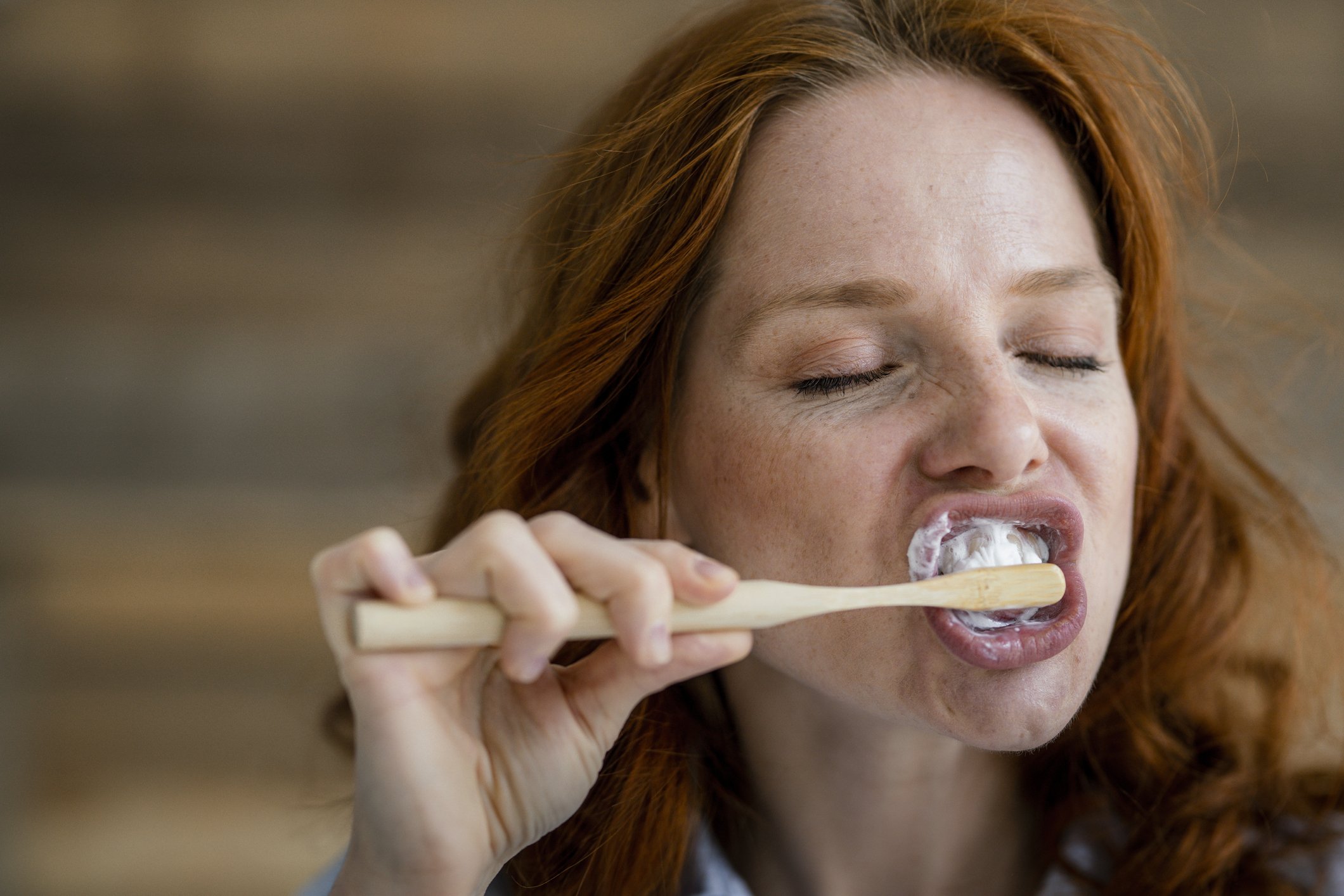 Rothaarige Frau putzt Zähne. I Foto: Getty Images