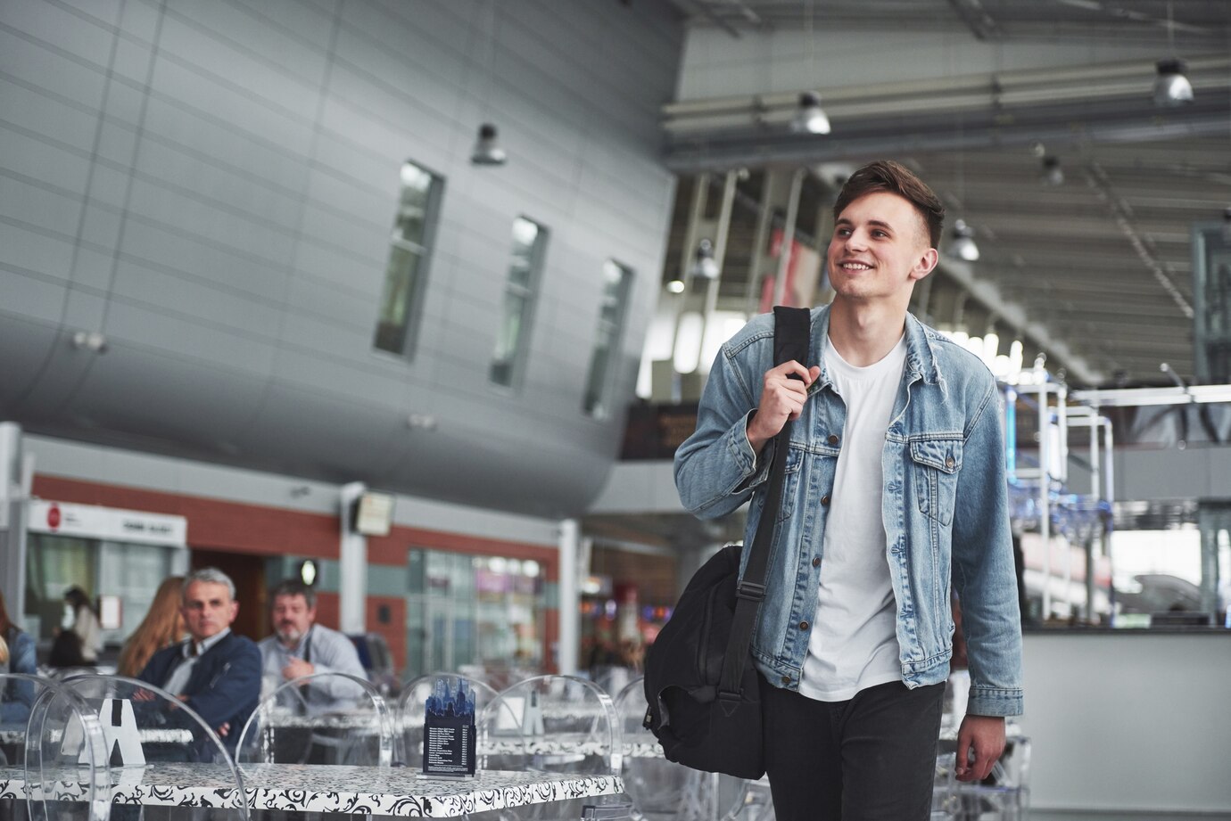 Ein lächelnder Mann auf einem Flughafen | Quelle: Freepik