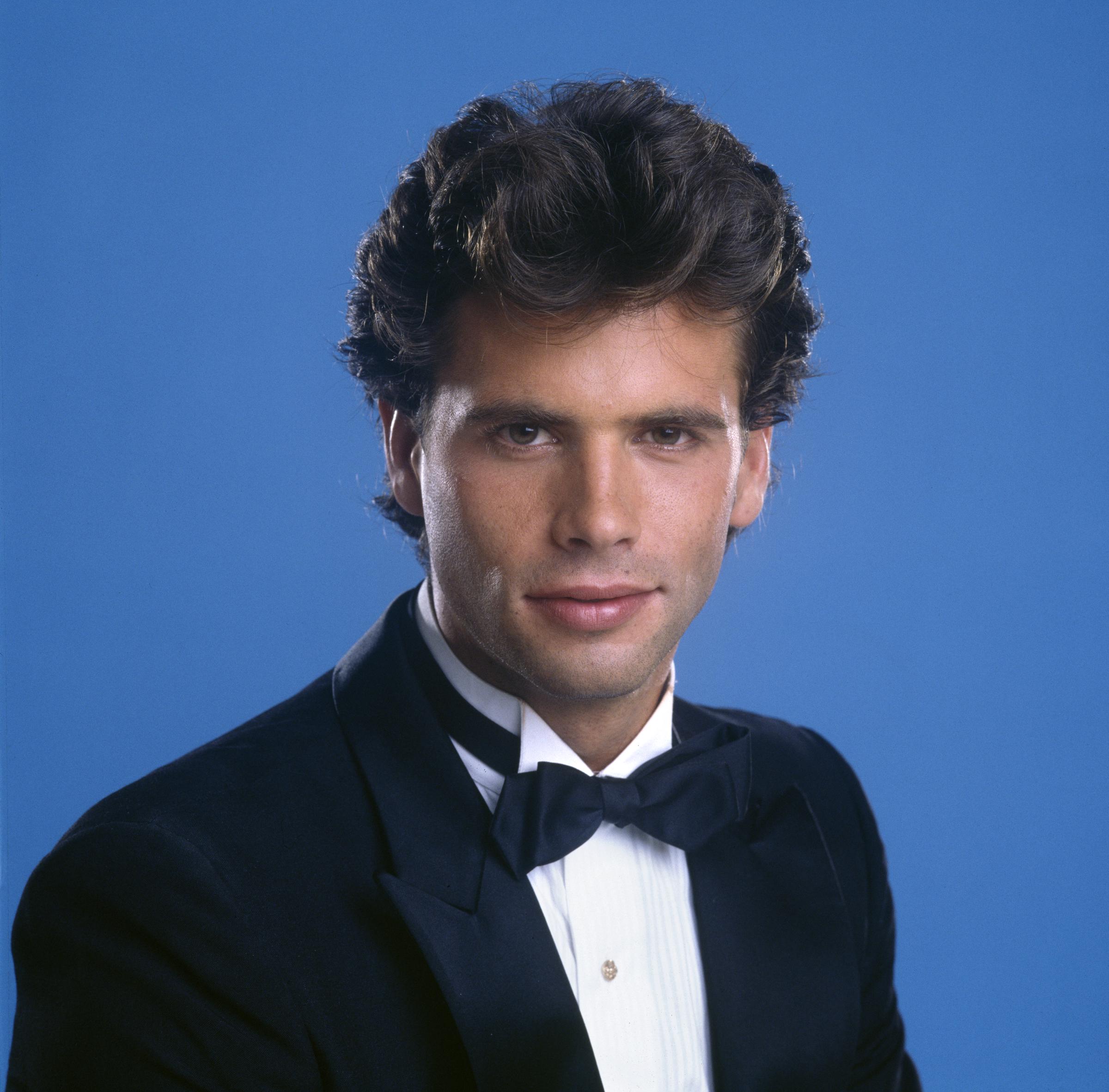 Lorenzo Lamas sieht absolut schick aus, während er am 1. Januar 1985 in Los Angeles, Kalifornien, eine CBS-Kurzsequenz für „In Celebration 1886–1986: An American Portrait“ dreht. Vor einem leuchtend königsblauen Hintergrund posiert der Schauspieler mit gestyltem, welligem dunklem Haar und einem klassischen schwarzen Smoking, komplett mit einem weißen Hemd mit Manschetten und einer schwarzen Fliege. | Quelle: Getty Images