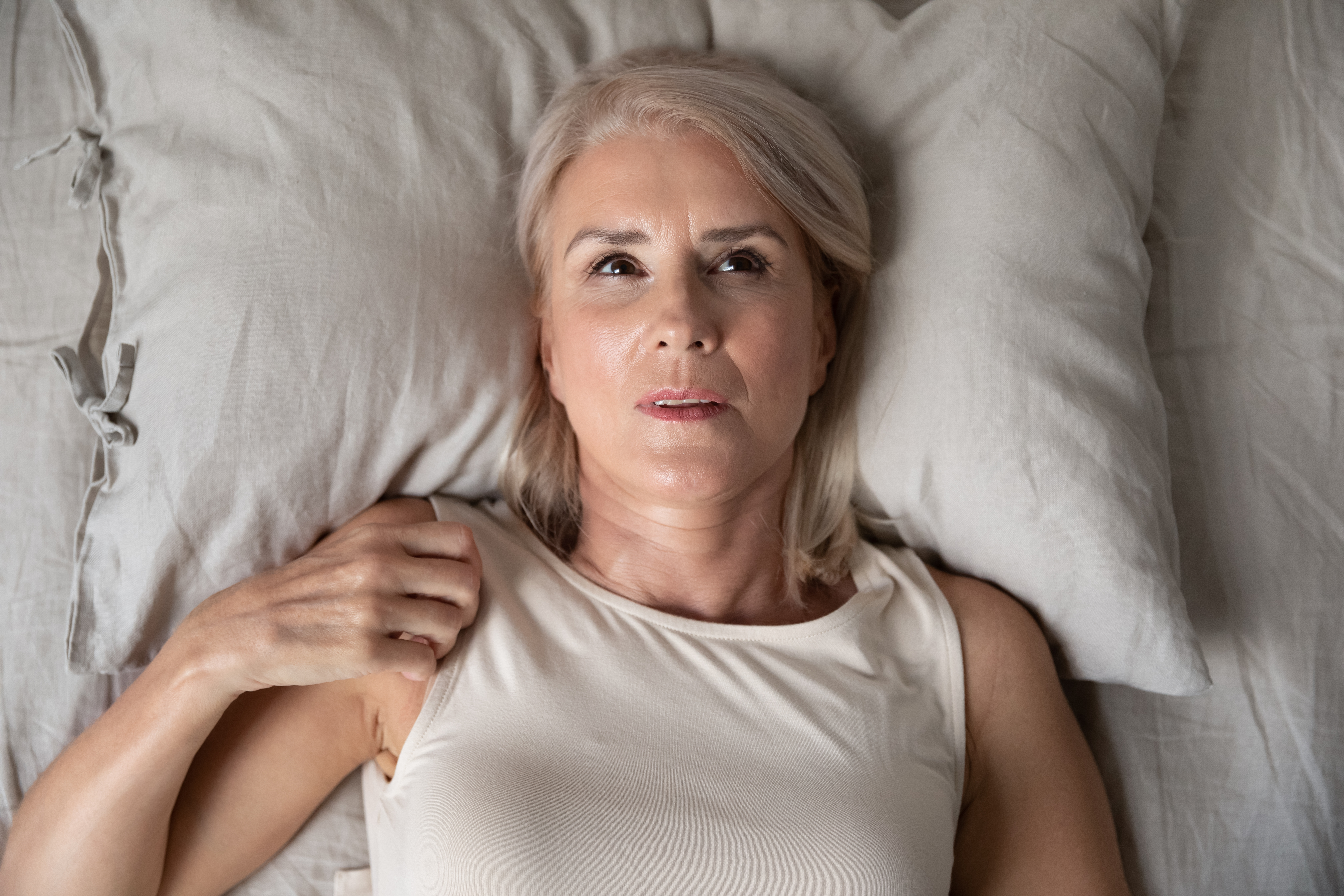 Eine Frau liegt wach im Bett | Quelle: Shutterstock