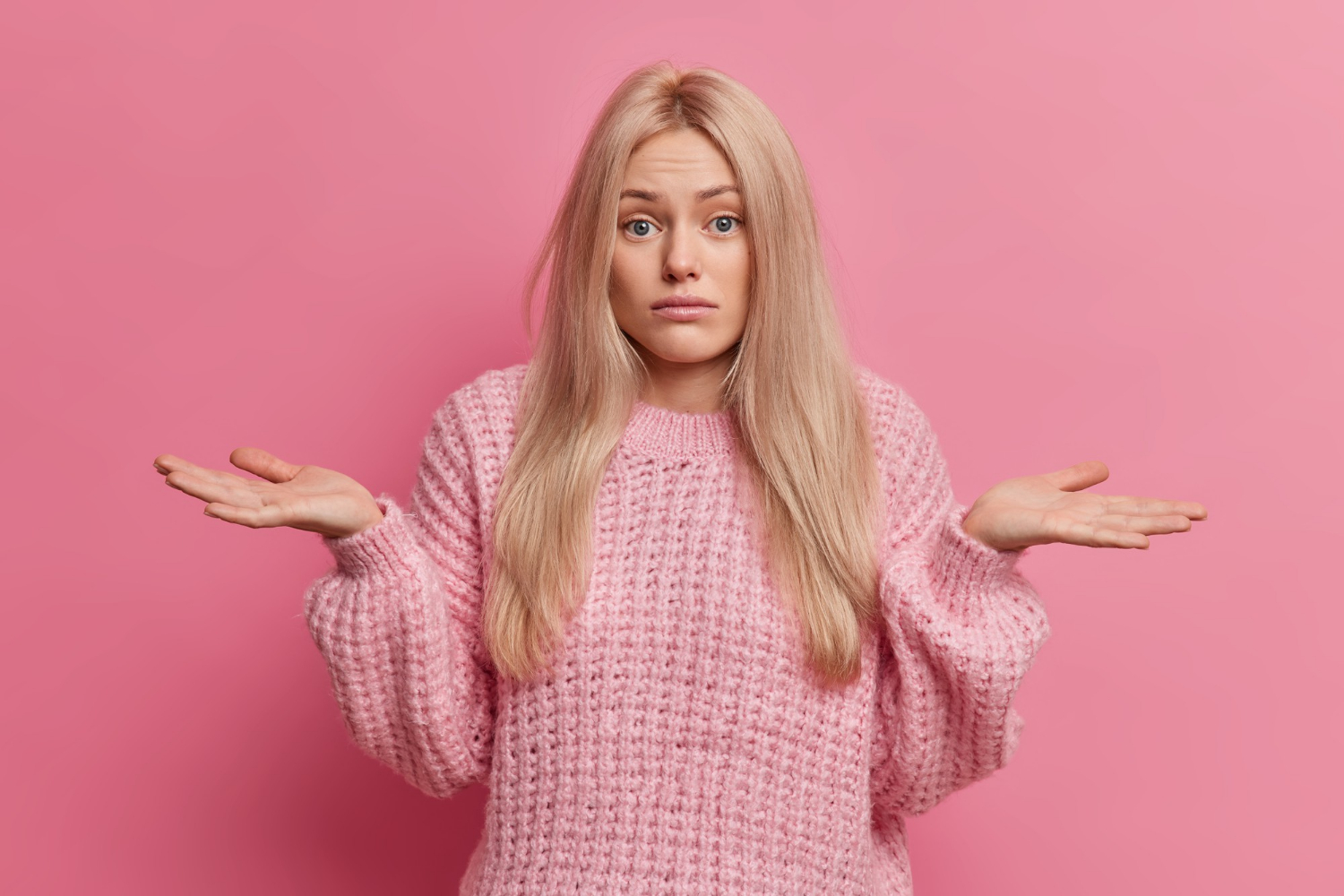 Eine frustrierte Frau zuckt mit den Schultern | Quelle: Freepik
