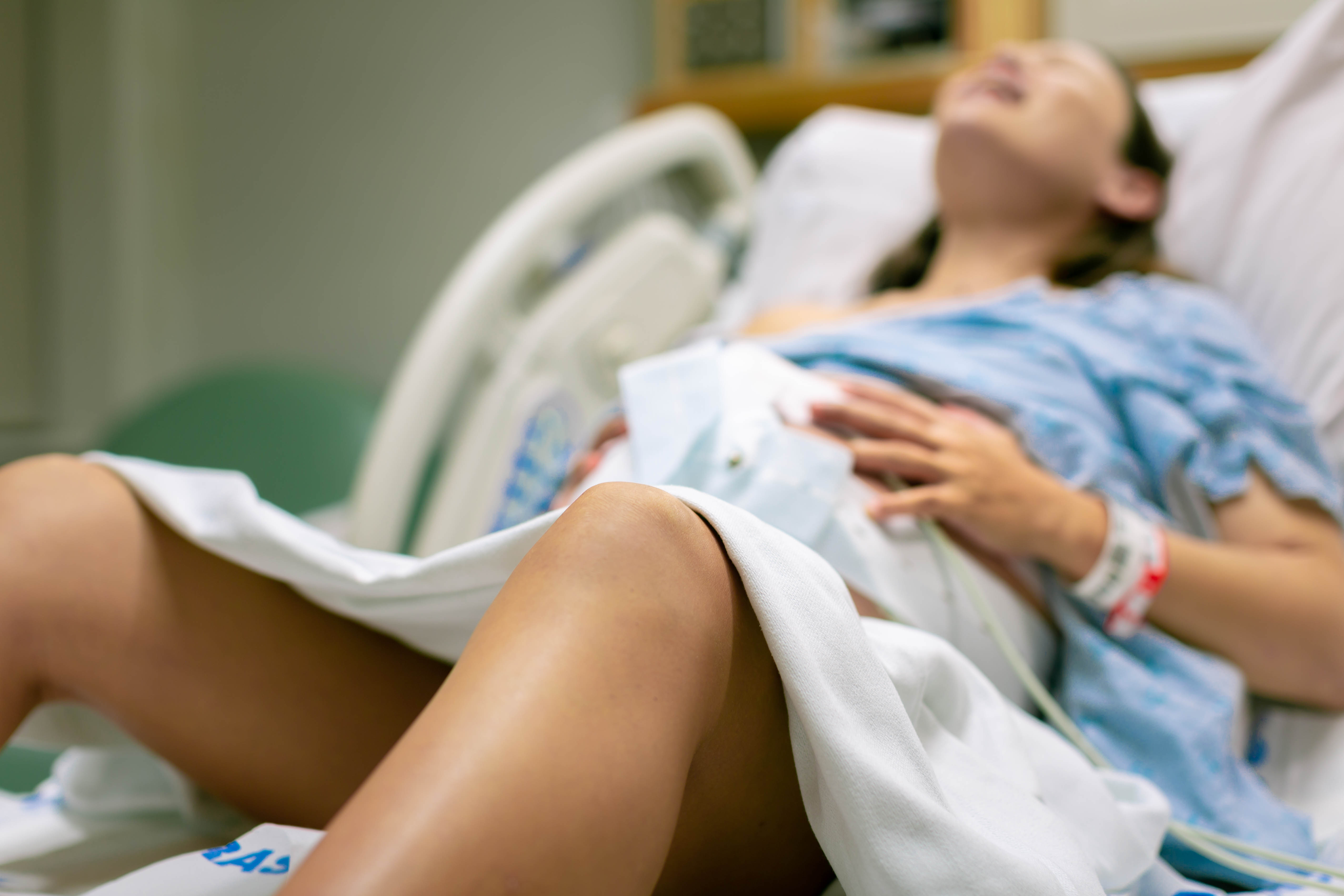 Ein Foto von einer Frau in den Wehen, die im Krankenhausbett liegt | Quelle: Shutterstock
