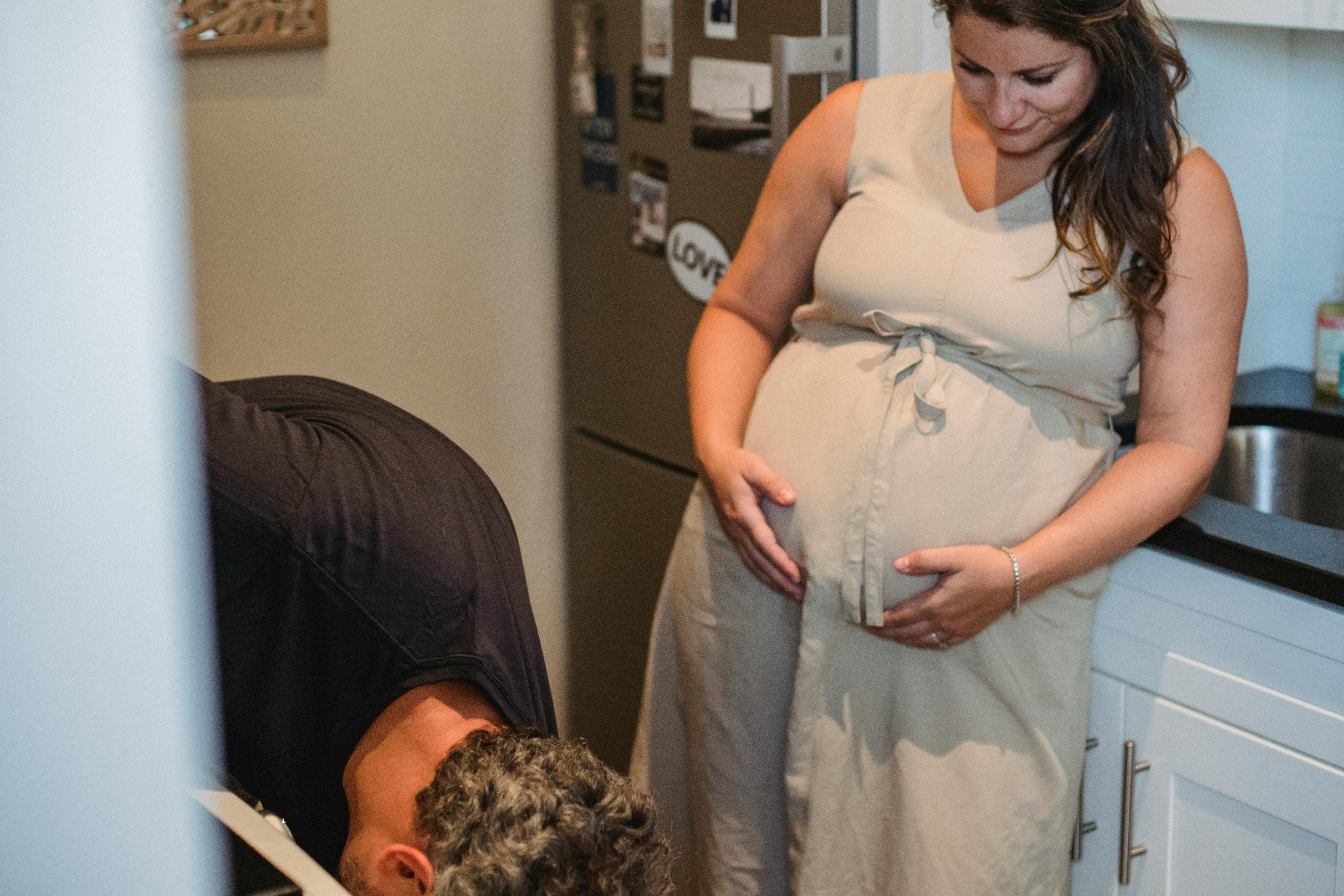 Eine schwangere Frau, die ihren Bauch berührt, während sie ihren Mann ansieht | Quelle: Pexels
