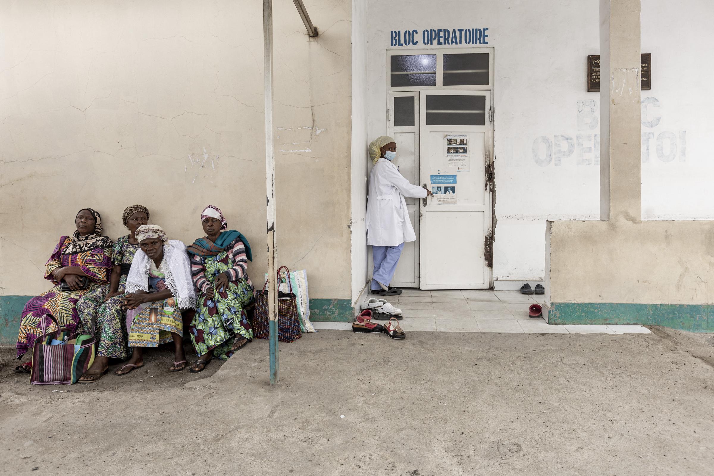 Eine Krankenschwester betritt den Operationssaal eines Krankenhauses in der Demokratischen Republik Kongo, während draußen Frauen warten | Quelle: Getty Images