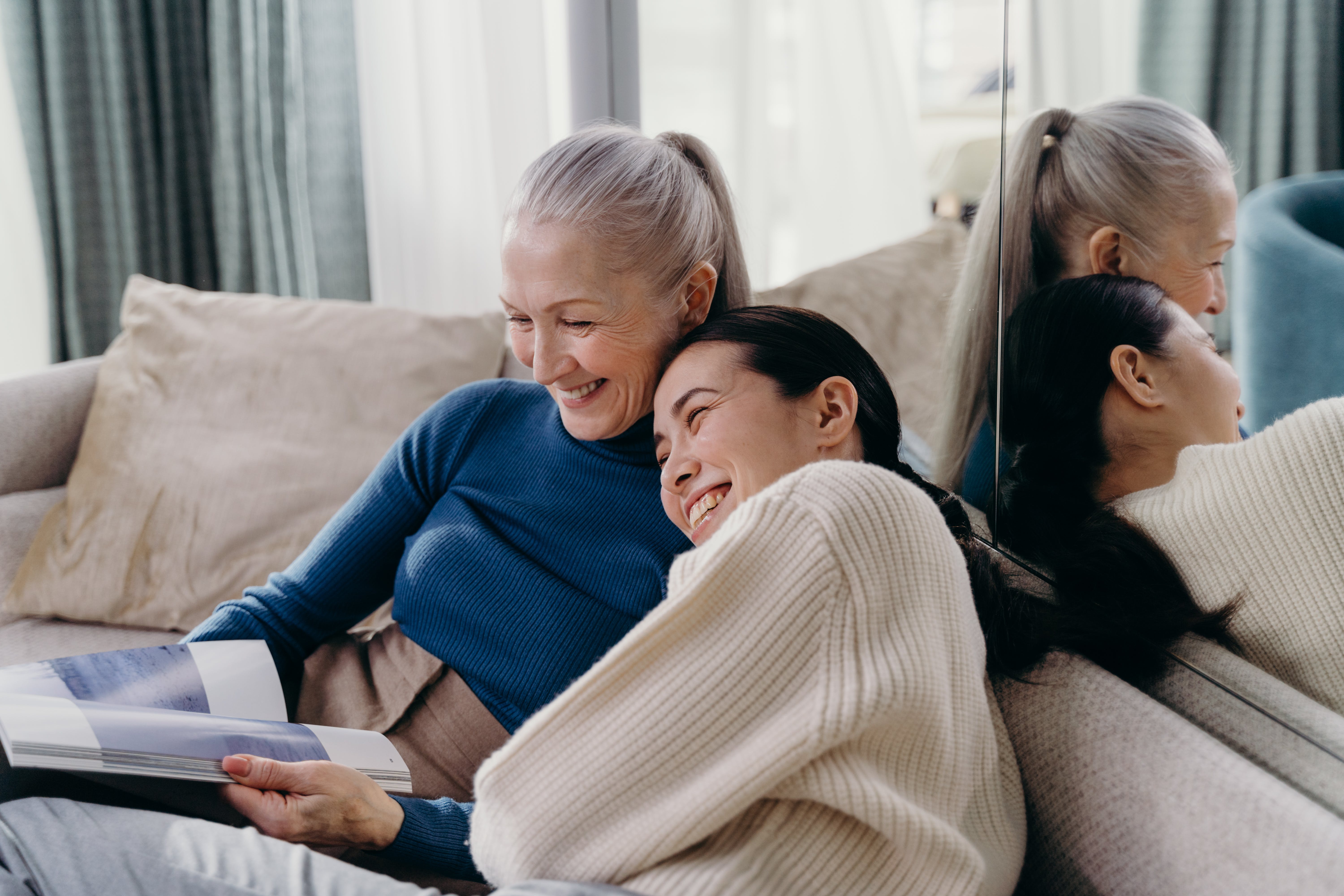 Eine ältere Frau lacht mit einer jungen Frau auf der Couch | Quelle: Pexels