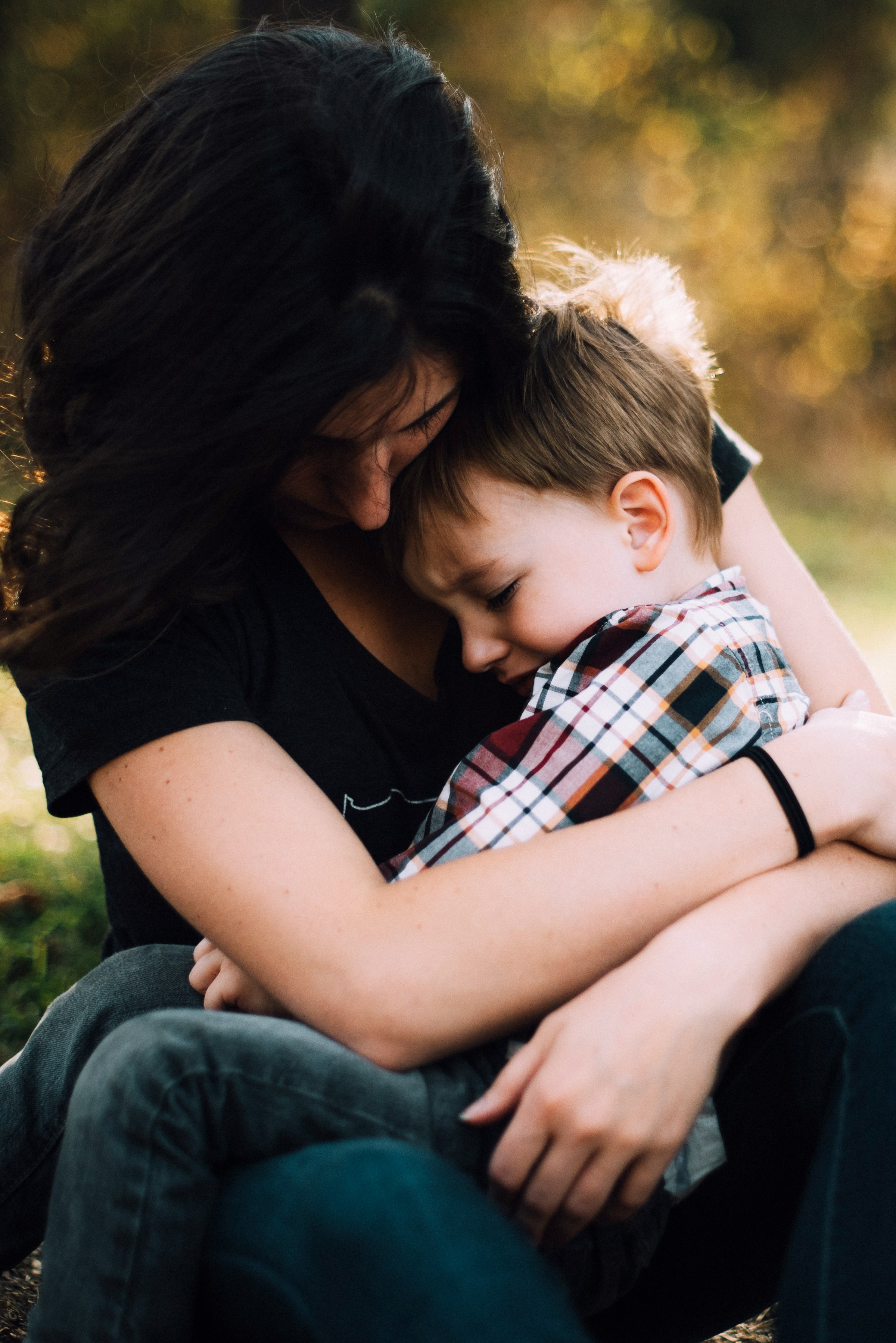 Eine Frau, die einen weinenden kleinen Jungen umarmt | Quelle: Unsplash