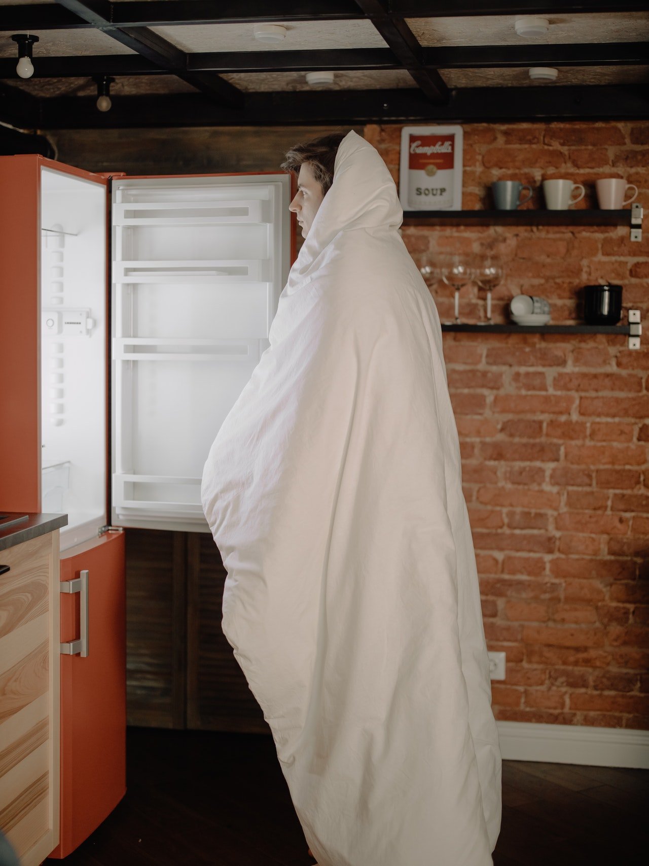 Foto eines Mannes, der vor einem offenen Kühlschrank steht | Quelle: Pexels