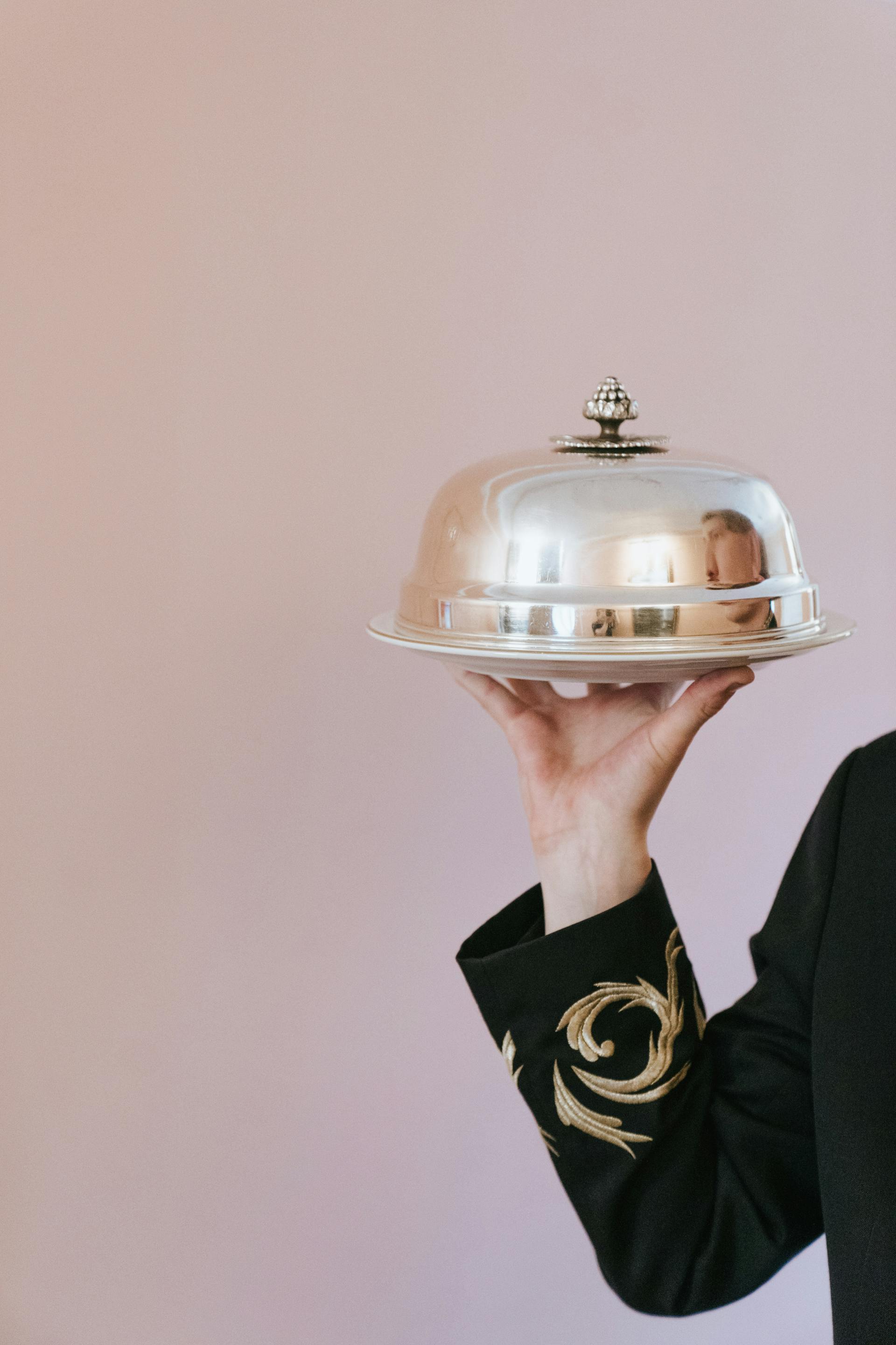 Eine Person hält eine Schale, die von einer Cloche bedeckt ist | Quelle: Pexels