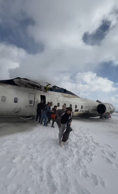 Rauch dringt aus dem Flugzeug, während weitere Passagiere aussteigen und sich über den schneebedeckten Boden bewegen | Quelle: Instagram.com/eggxit