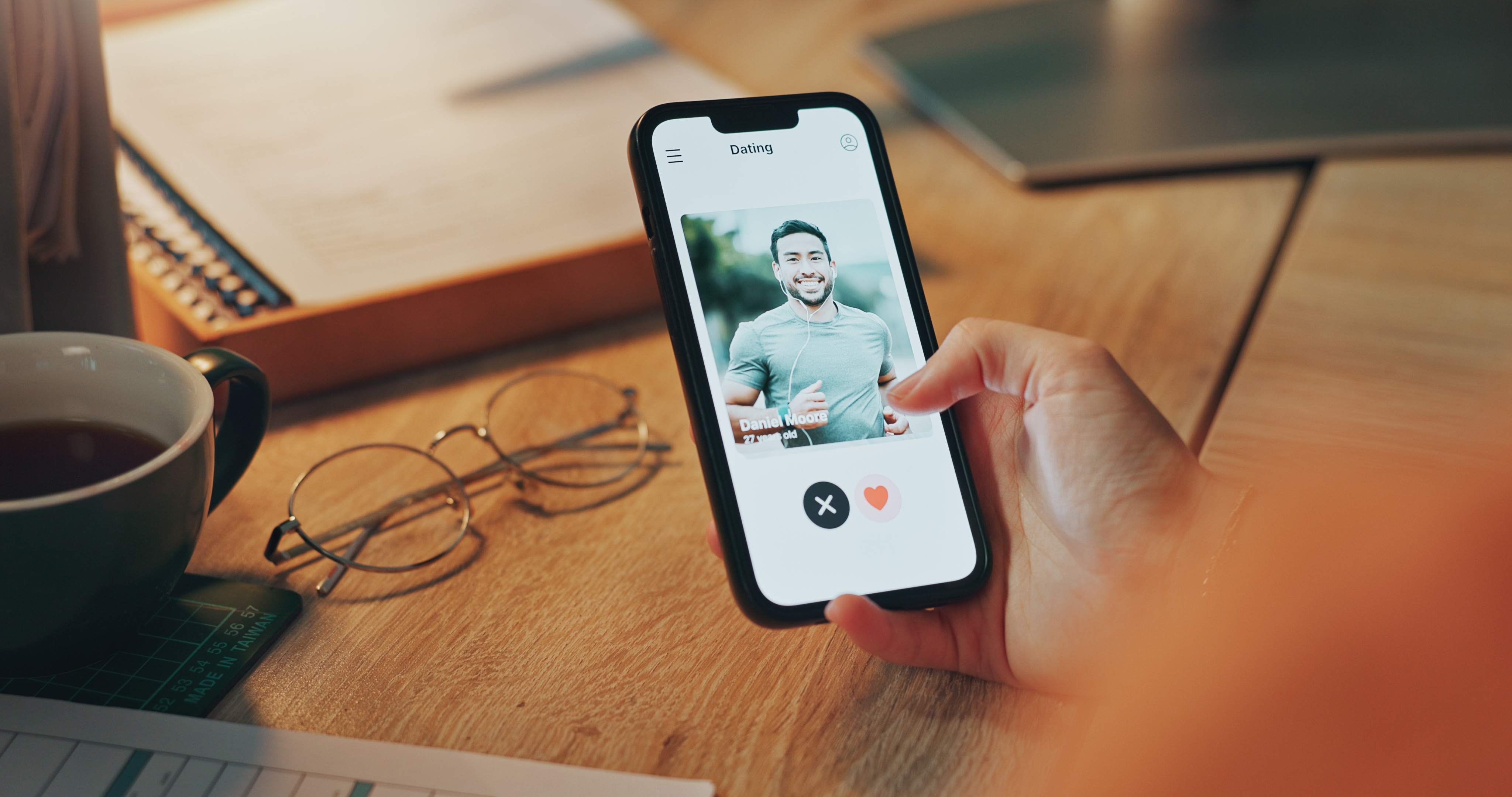 Telefonbildschirm, Hand einer Person und Person auf Dating-App | Quelle: Shutterstock