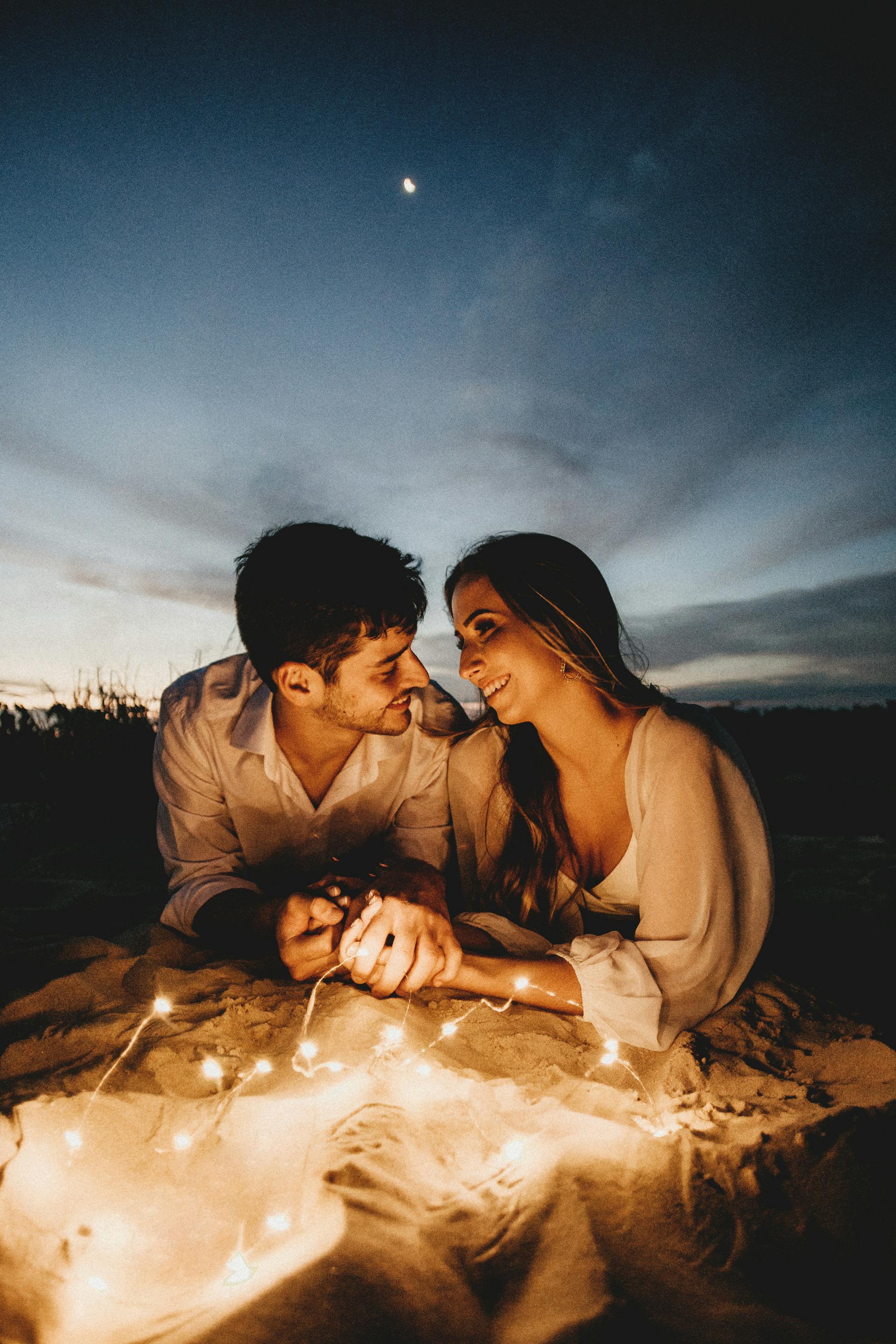 Ein liebendes Paar hält abends Händchen | Quelle: Pexels