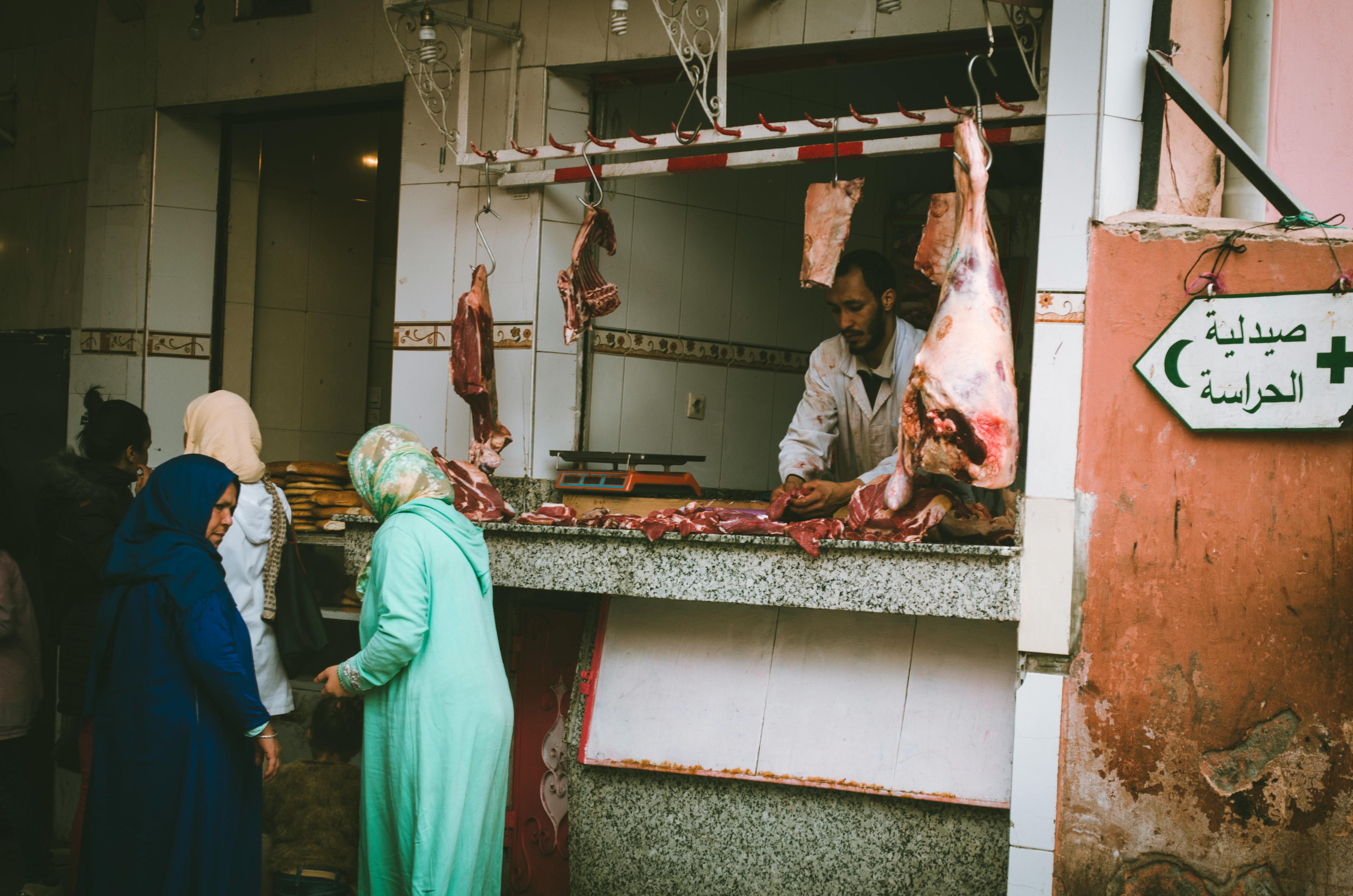 Menschen kaufen Fleisch in einer Metzgerei | Quelle: Pexels