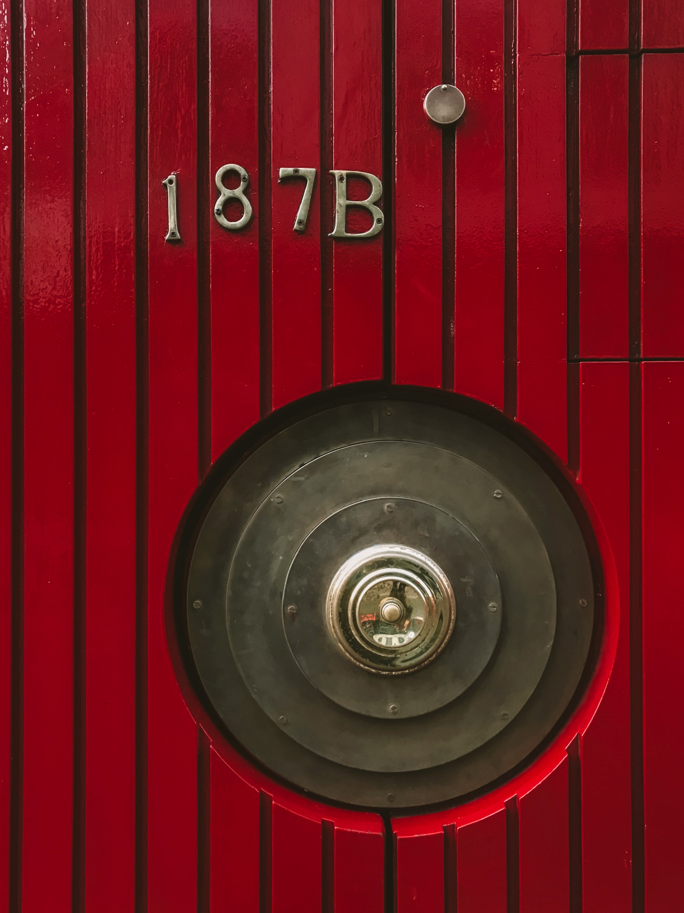 Eine rote Tür mit einem Türknauf aus Metall | Quelle: Unsplash