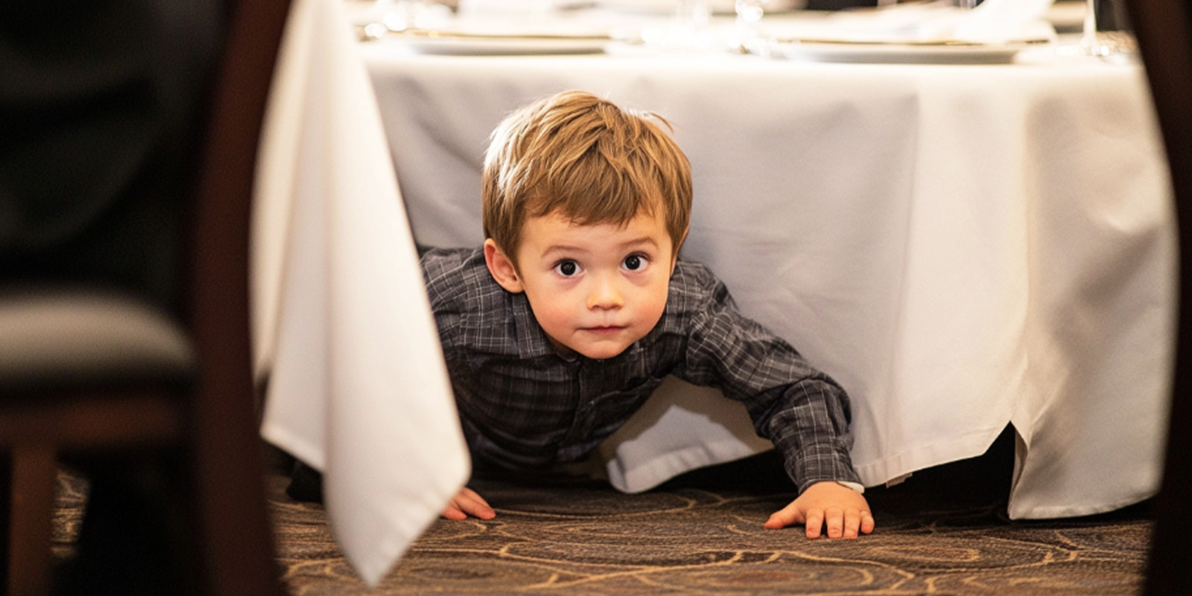 Ein Kind krabbelt unter einem Tisch hervor | Quelle: The Celebritist