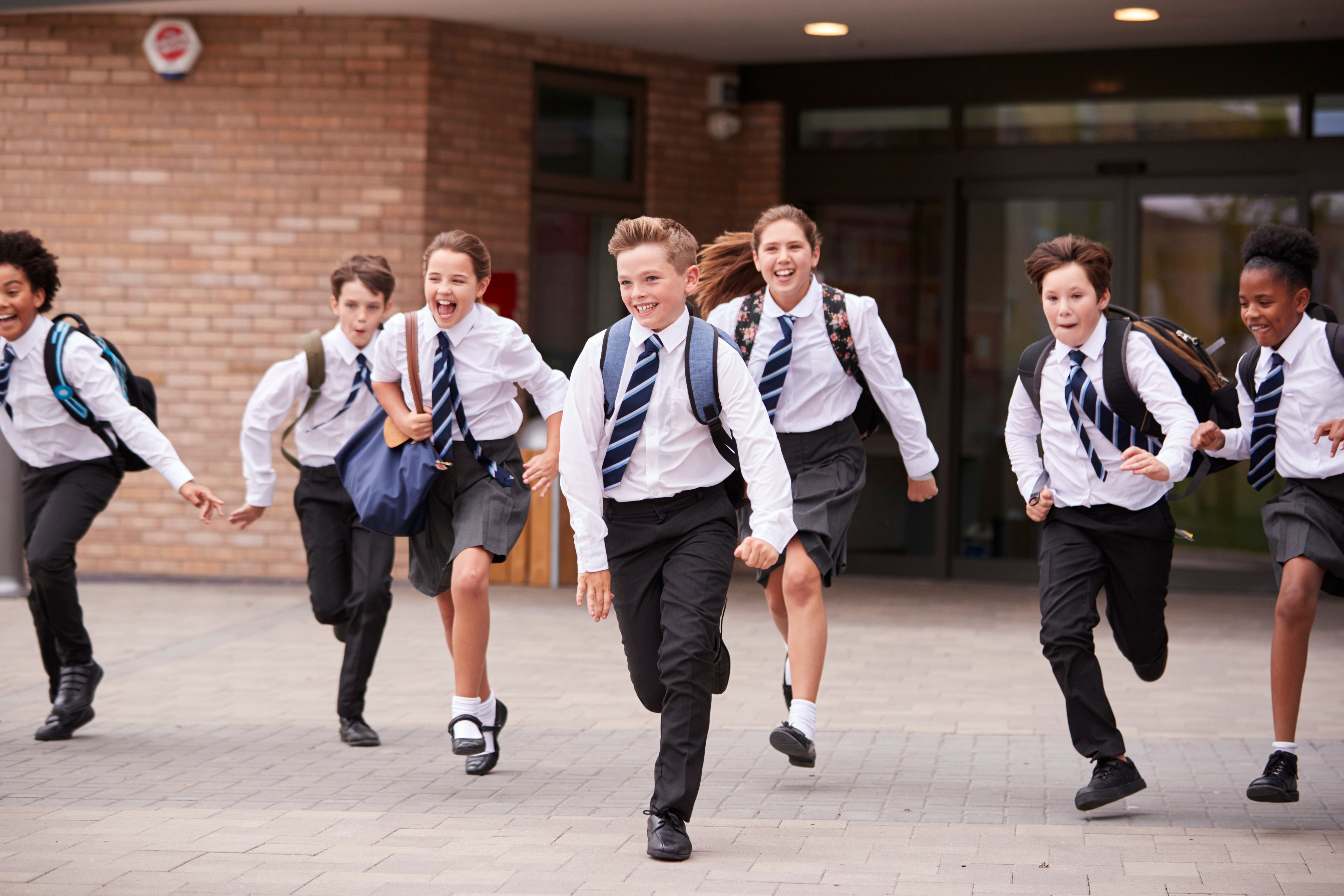 Schüler rennen vor der Schule. | Quelle: Shutterstock