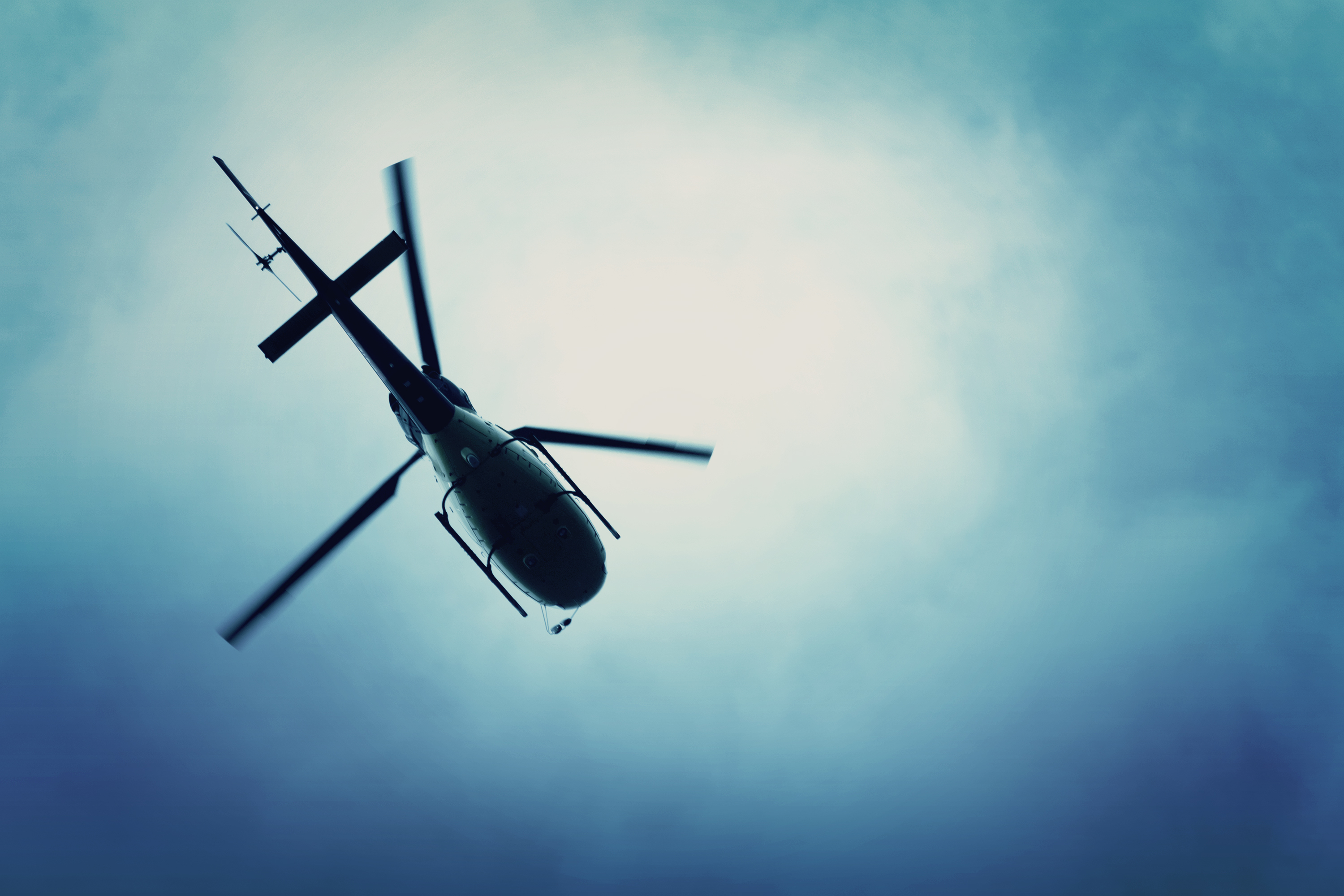 Ein Hubschrauber fliegt in den blauen Himmel. | Quelle: Shutterstock