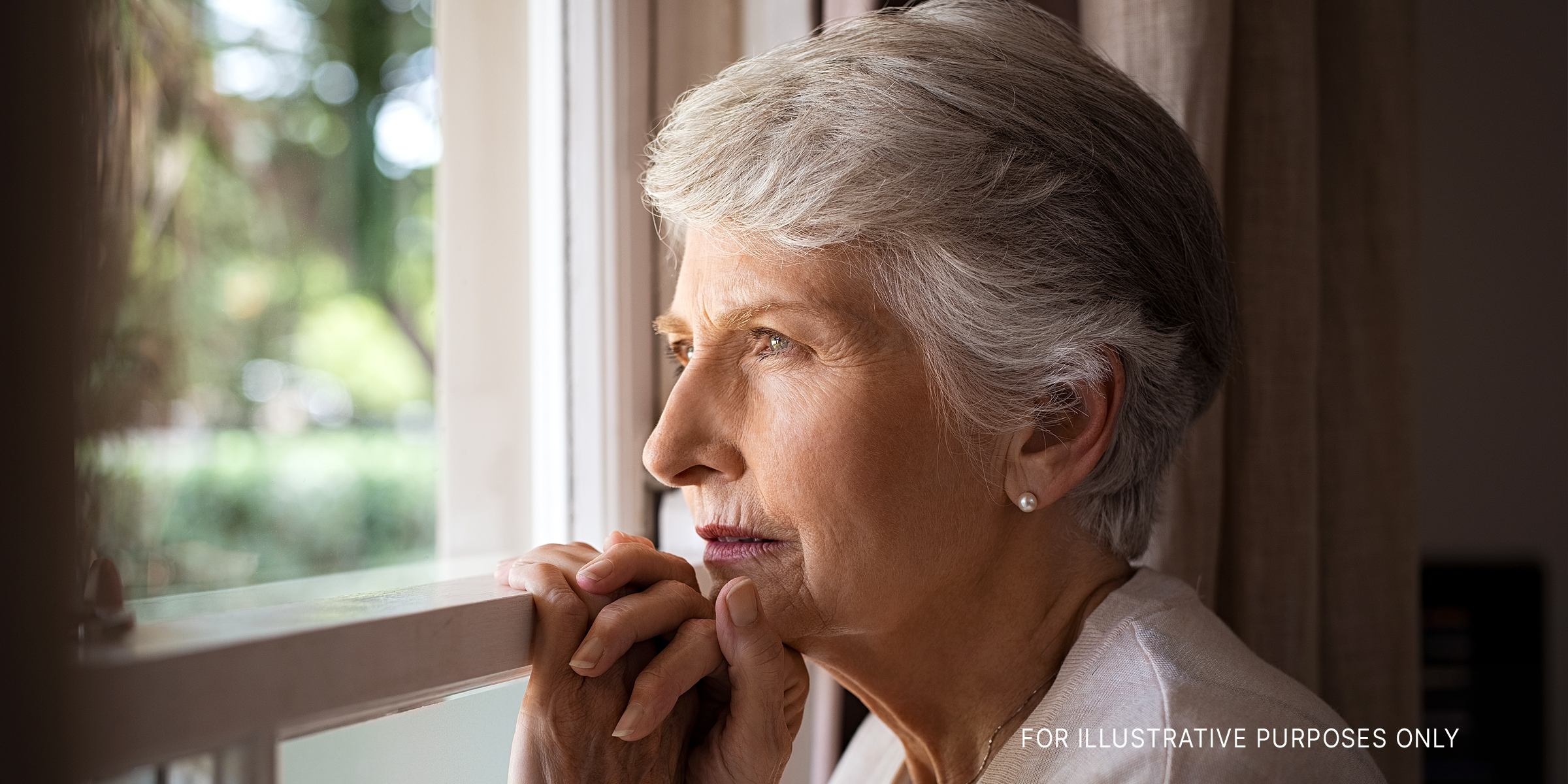 Ältere Frau schaut aus dem Fenster | Quelle: Getty Images