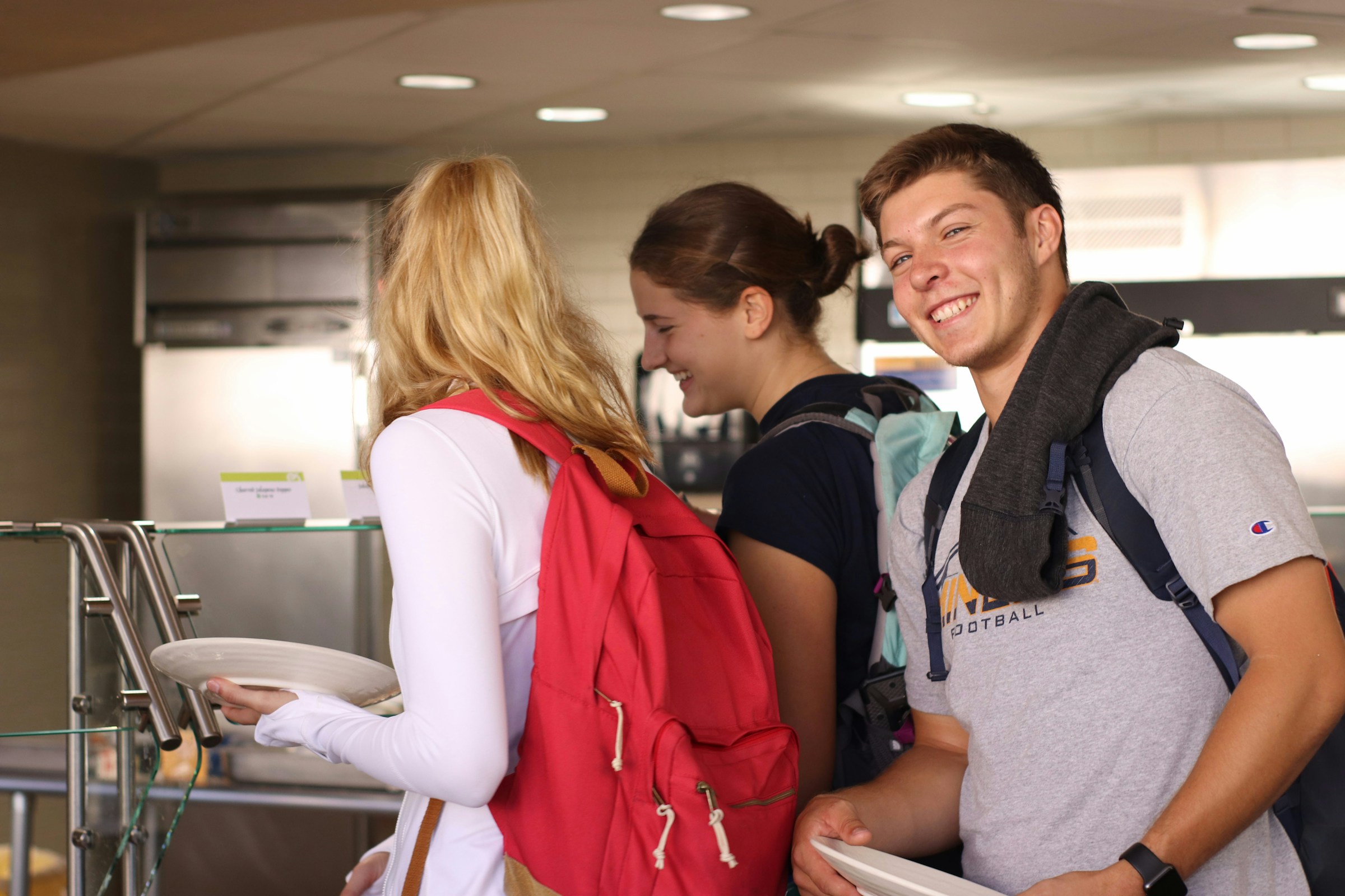 College-Studenten halten Teller in einer Cafeteria | Quelle: Unsplash