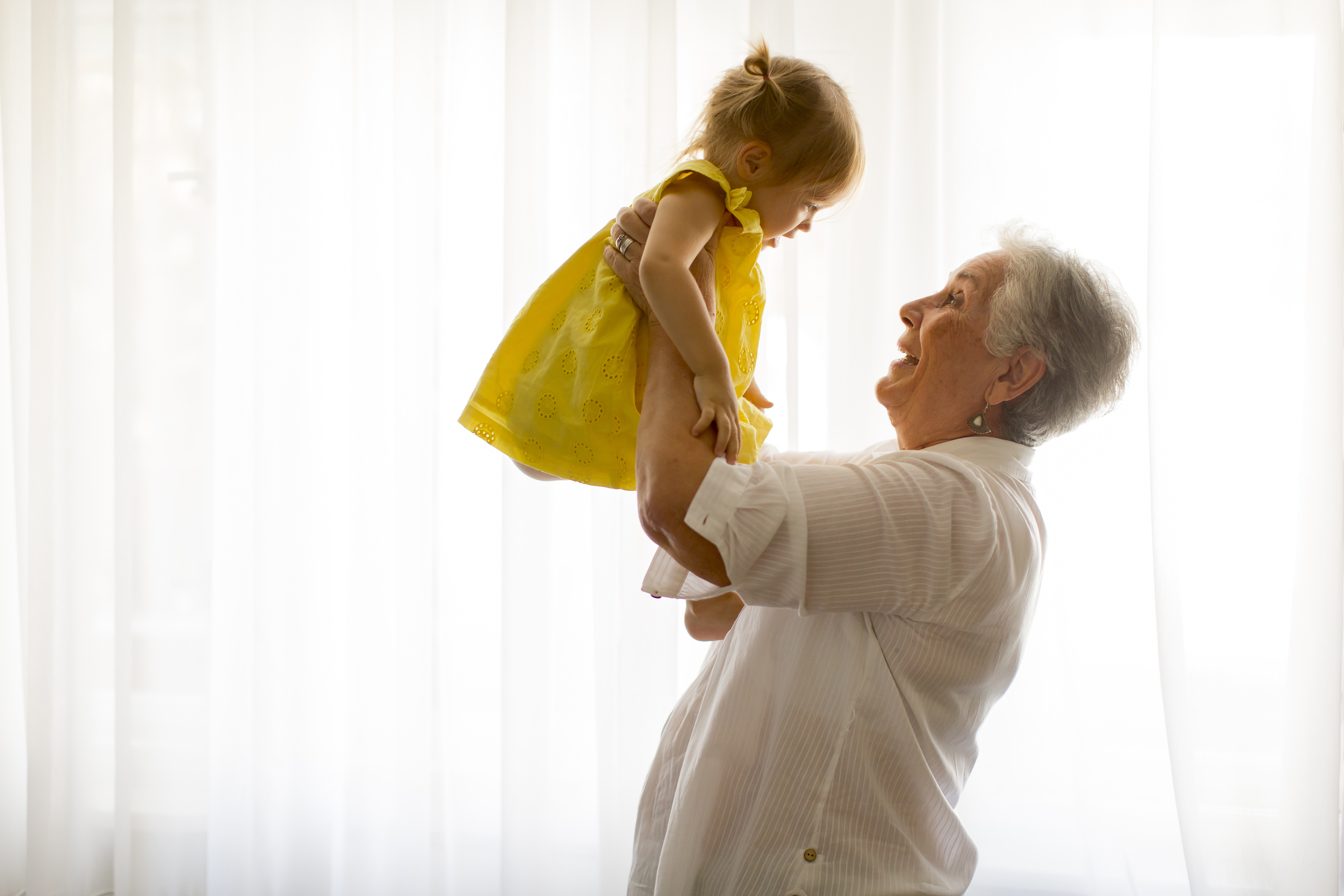 Eine Großmutter hält ihre Enkelin im Arm | Quelle: Shutterstock