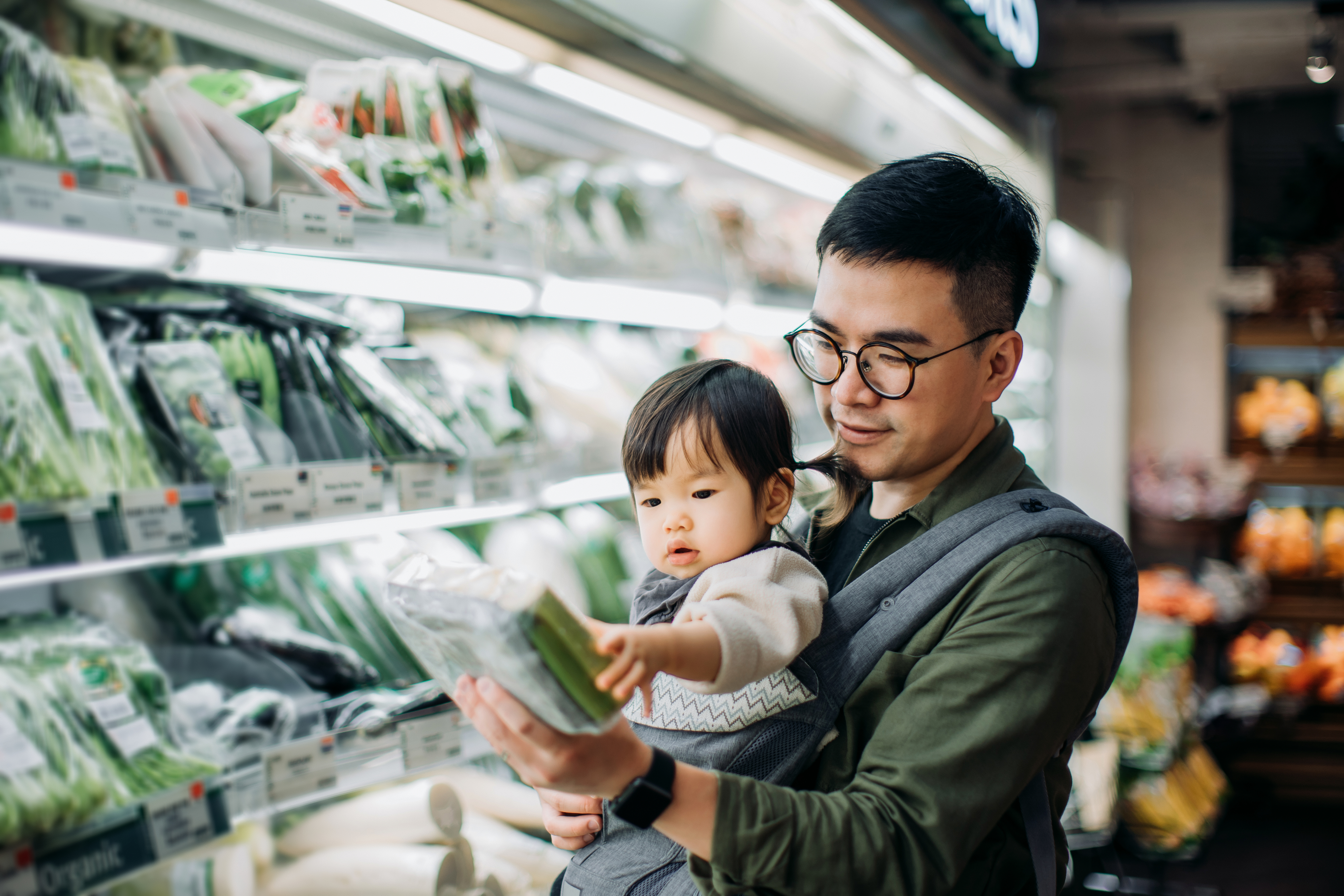 Asiatischer Mann und seine Tochter beim Einkaufen in einem Supermarkt | Quelle: Getty Images