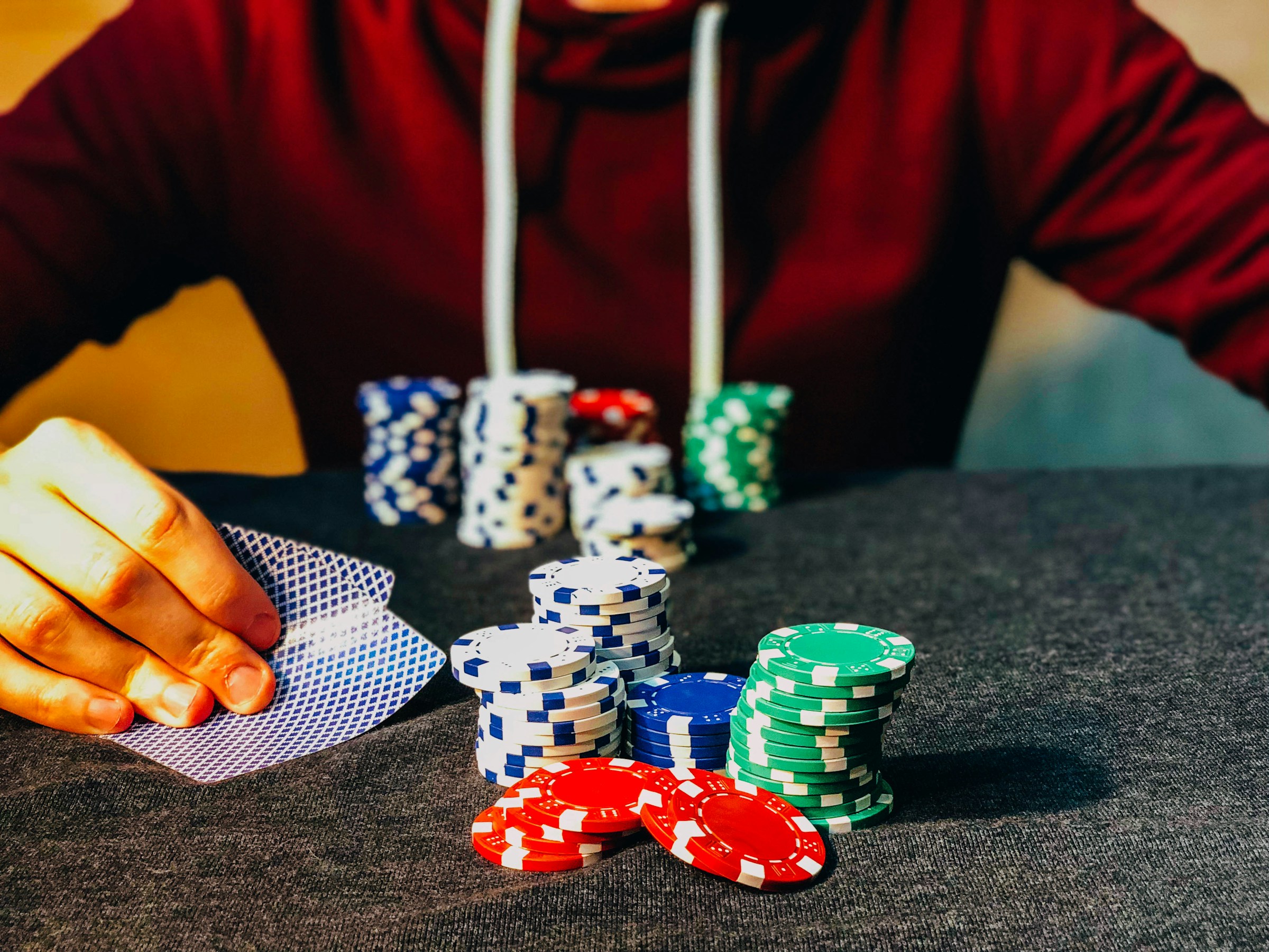 Ein Mann in einem Casino, der mit Pokerchips sitzt | Quelle: Unsplash