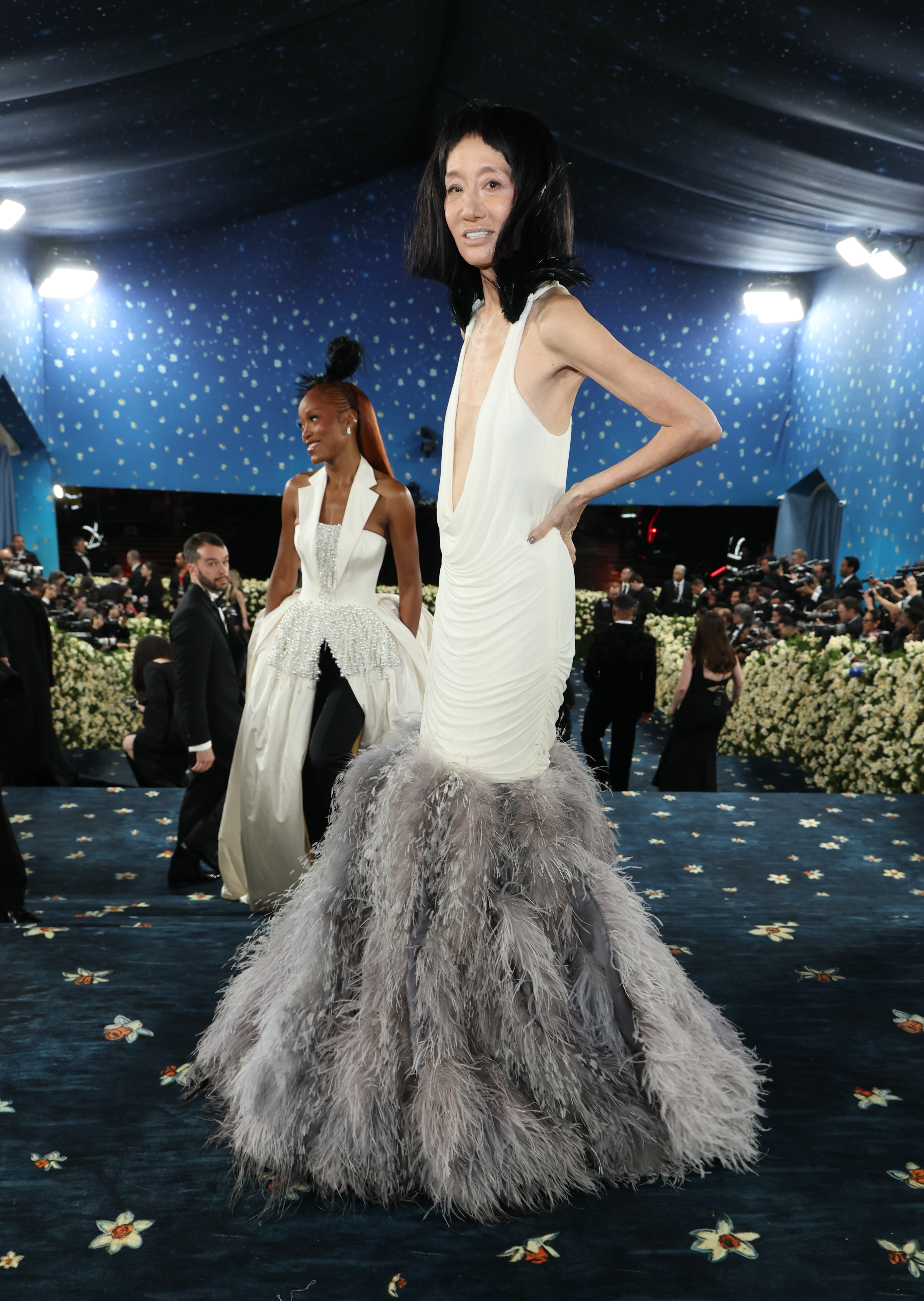 Umgeben von einem Meer aus Kameras und Blumendekoration posiert Vera Wang in ihrer strukturierten Robe mitten im Schritt, während Keke Palmer hinter ihr folgt.
