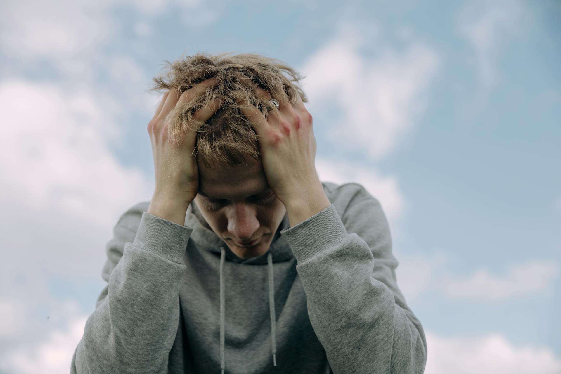 Ein Mann sitzt mit seinem Kopf in den Händen | Quelle: Pexels