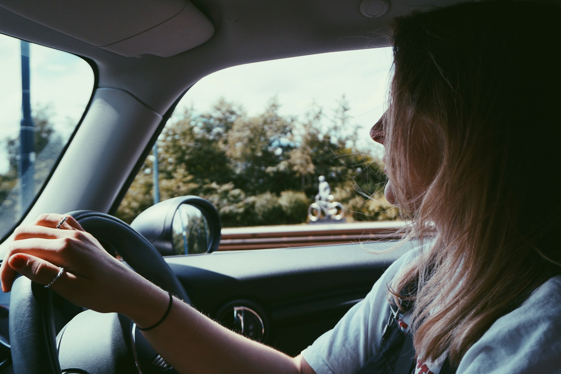 Eine fröhliche Frau am Steuer eines Autos | Quelle: Unsplash