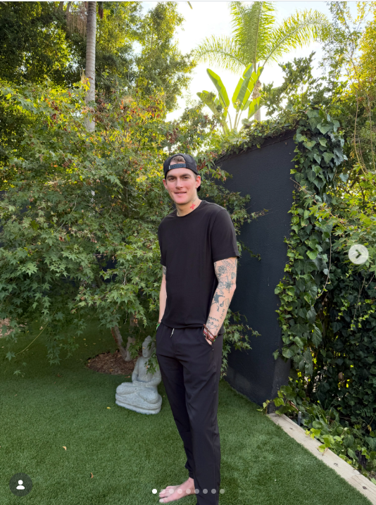 Presley Gerber posiert am 6. August 2026 barfuß in einem üppigen Garten – ganz in Schwarz gekleidet und mit einer Baseballkappe verkehrt herum auf dem Kopf – und gibt damit einen Einblick in einen entspannten Moment seines Lebens abseits öffentlicher Veranstaltungen. | Quelle: Instagram/presleygerber