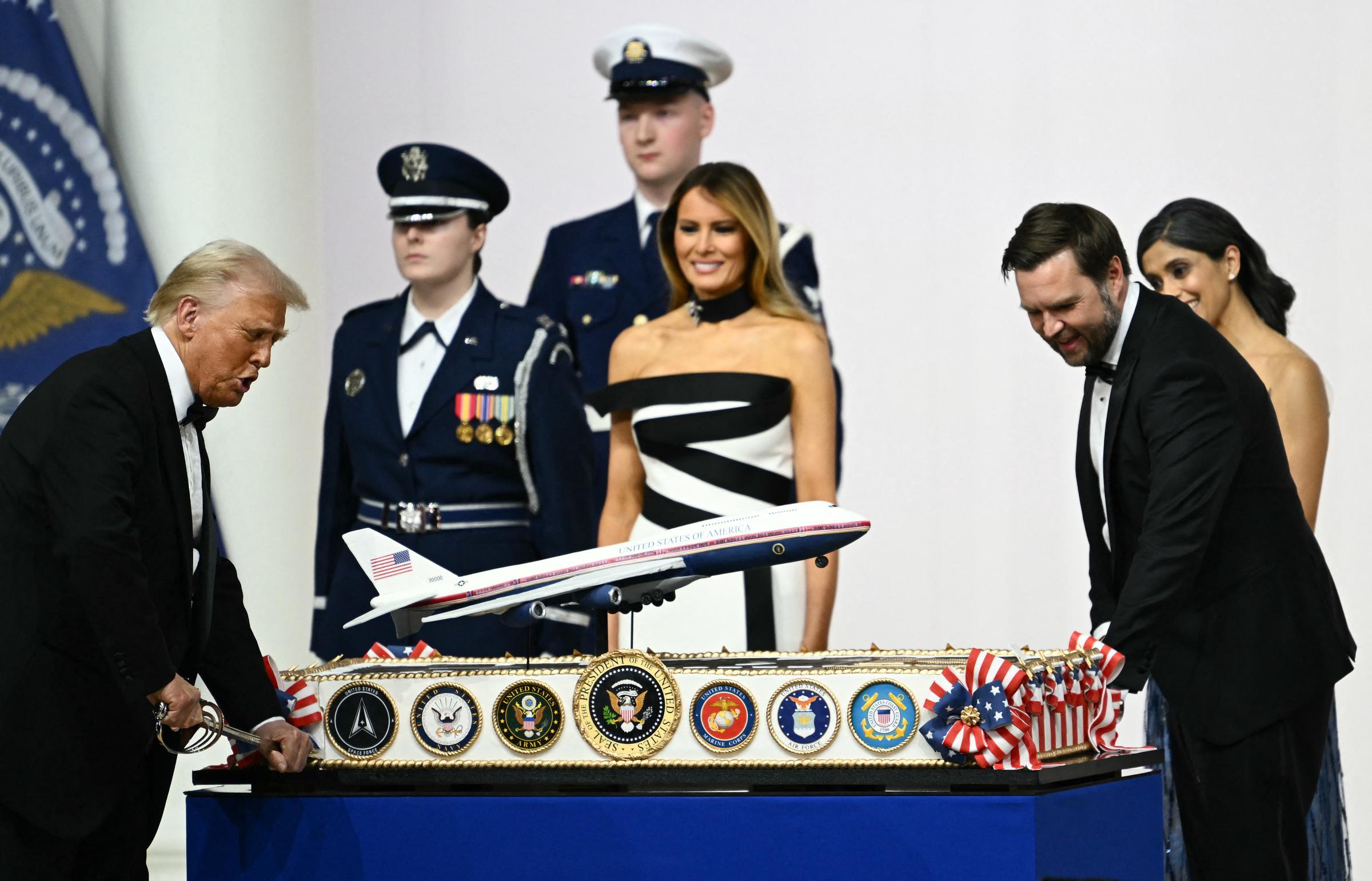 First Lady Melania Trump neben Usha Vance sieht zu, wie US-Präsident Donald Trump und Vizepräsident J.D. Vance während des Inaugurationsballs des Oberbefehlshabers am 20. Januar 2025 eine Torte anschneiden, die das neue Design der Air Force One mit einem Säbel darstellt | Quelle: Getty Images