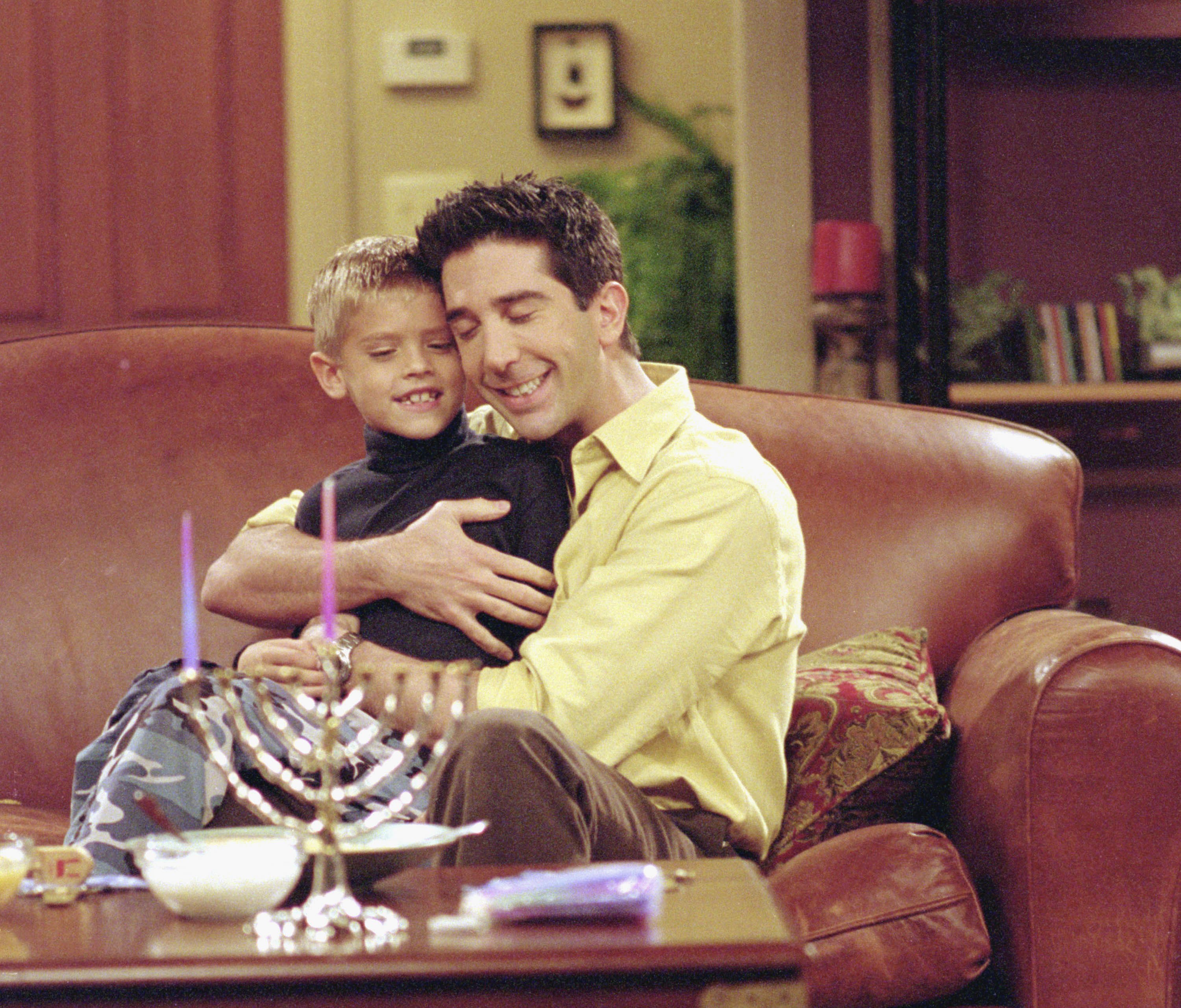 Cole Sprouse und David Schwimmer beim Drehen einer Szene in "Friends" im Jahr 2000. | Quelle: Getty Images