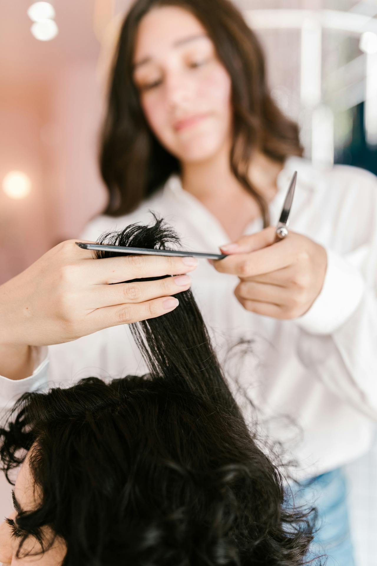 Ein Stylist schneidet einer Frau in einem Salon die Haare | Quelle: Pexels