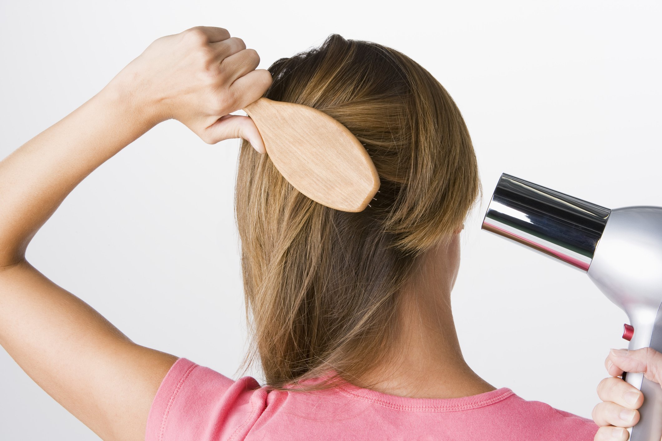 Frau bürstet und trocknet Haare | Quelle: Getty Images