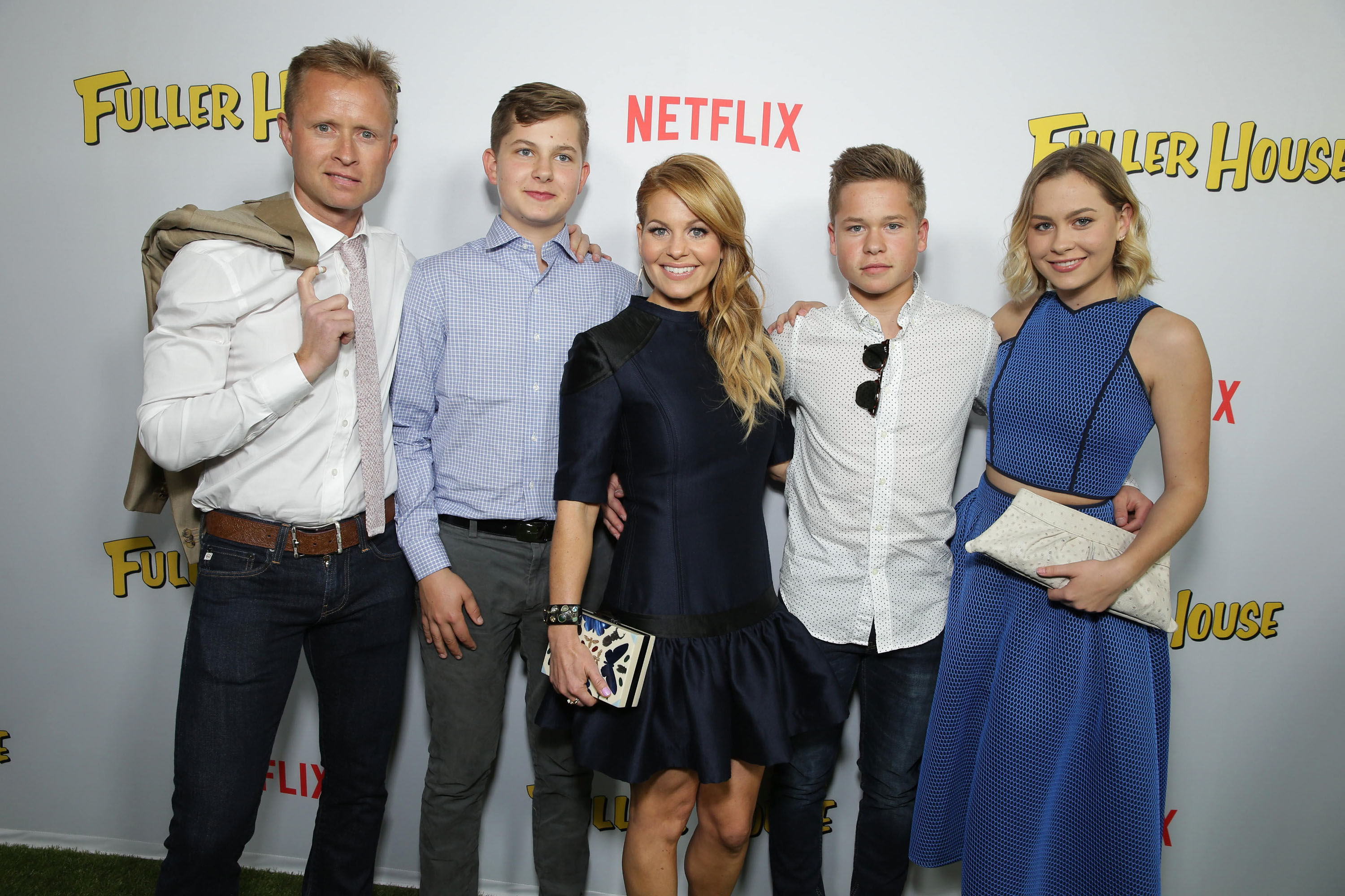 Candace Cameron Bure feiert am 16. Februar 2016 im „The Grove“ in Los Angeles gemeinsam mit ihrem Ehemann Valeri Bure und ihren Kindern – Lev, Maksim und Natasha – die Premiere von Netflix’ „Fuller House“. Die Schauspielerin strahlt in einem maßgeschneiderten marineblauen Minikleid mit Lederakzenten an den Schultern und einem voluminösen Saum und posiert Arm in Arm mit ihrem jüngeren Sohn Maksim, der in einem weiß gepunkteten Hemd und dunkler Jeans richtig schick aussieht. | Quelle: Getty Images